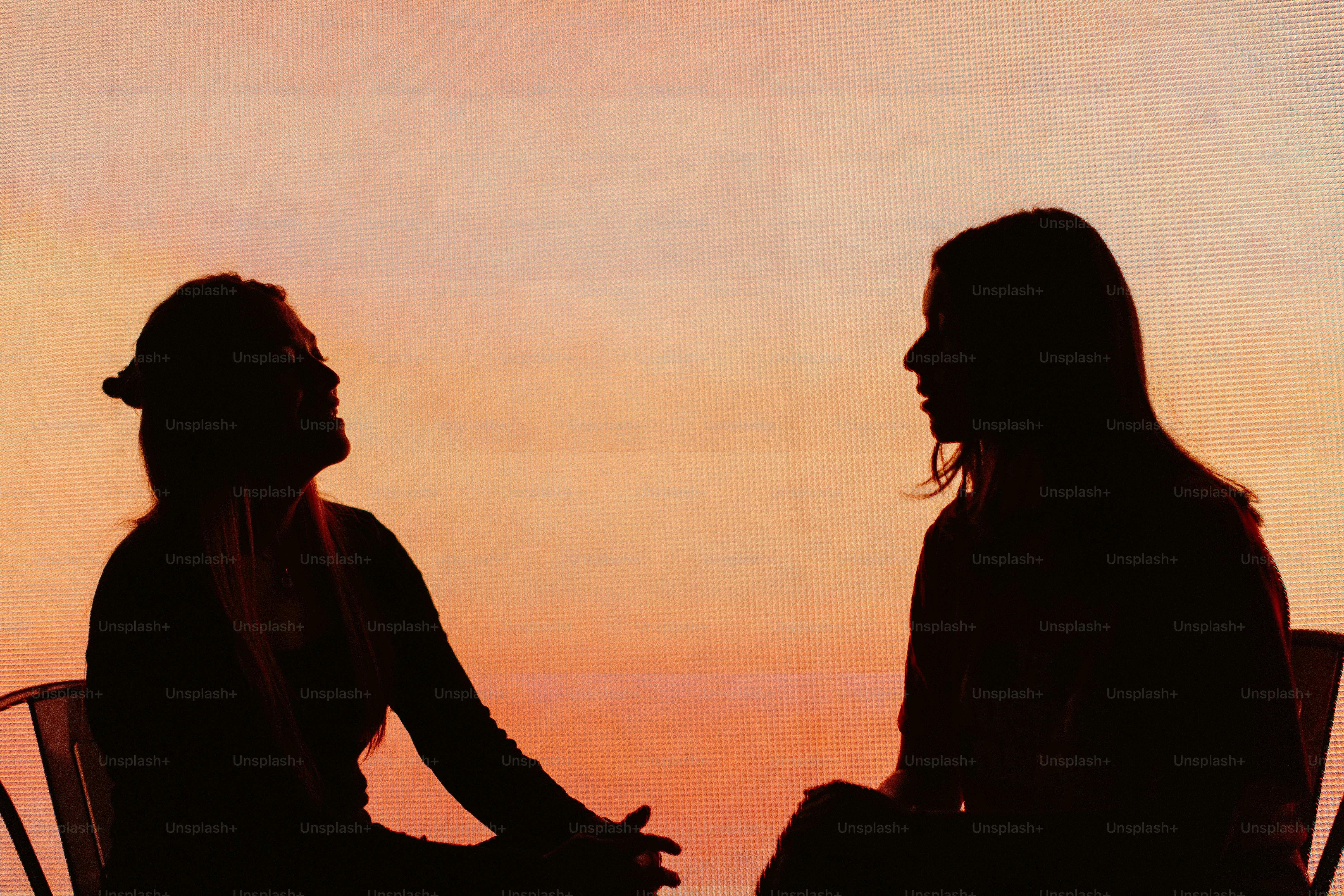 Two people silhouetted against a sunset