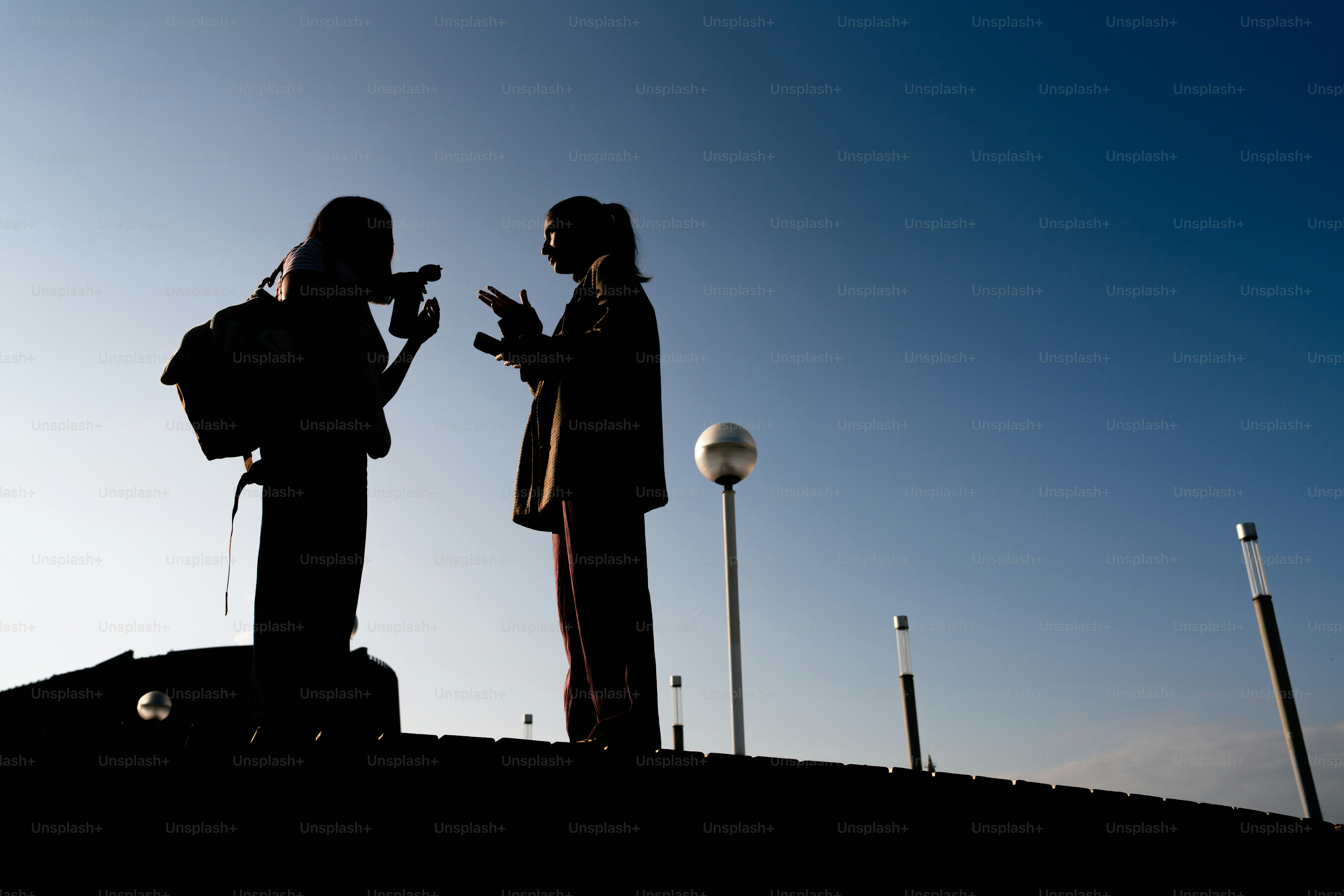 맑은 푸른 하늘을 배경으로 두 사람이 실루엣을 드러냈다.