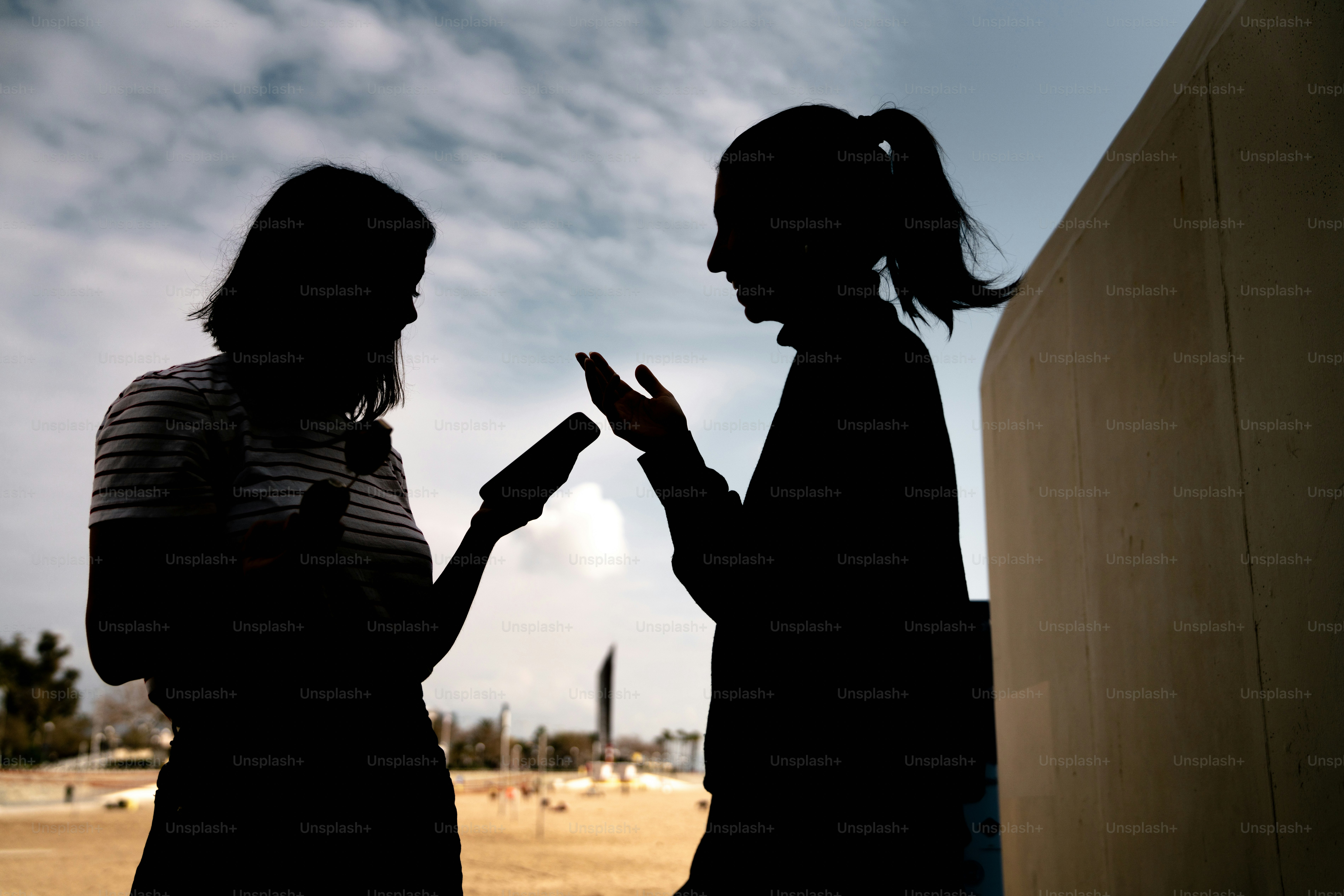 하늘을 배경으로 두 여성의 실루엣이 대화를 나누고 있다