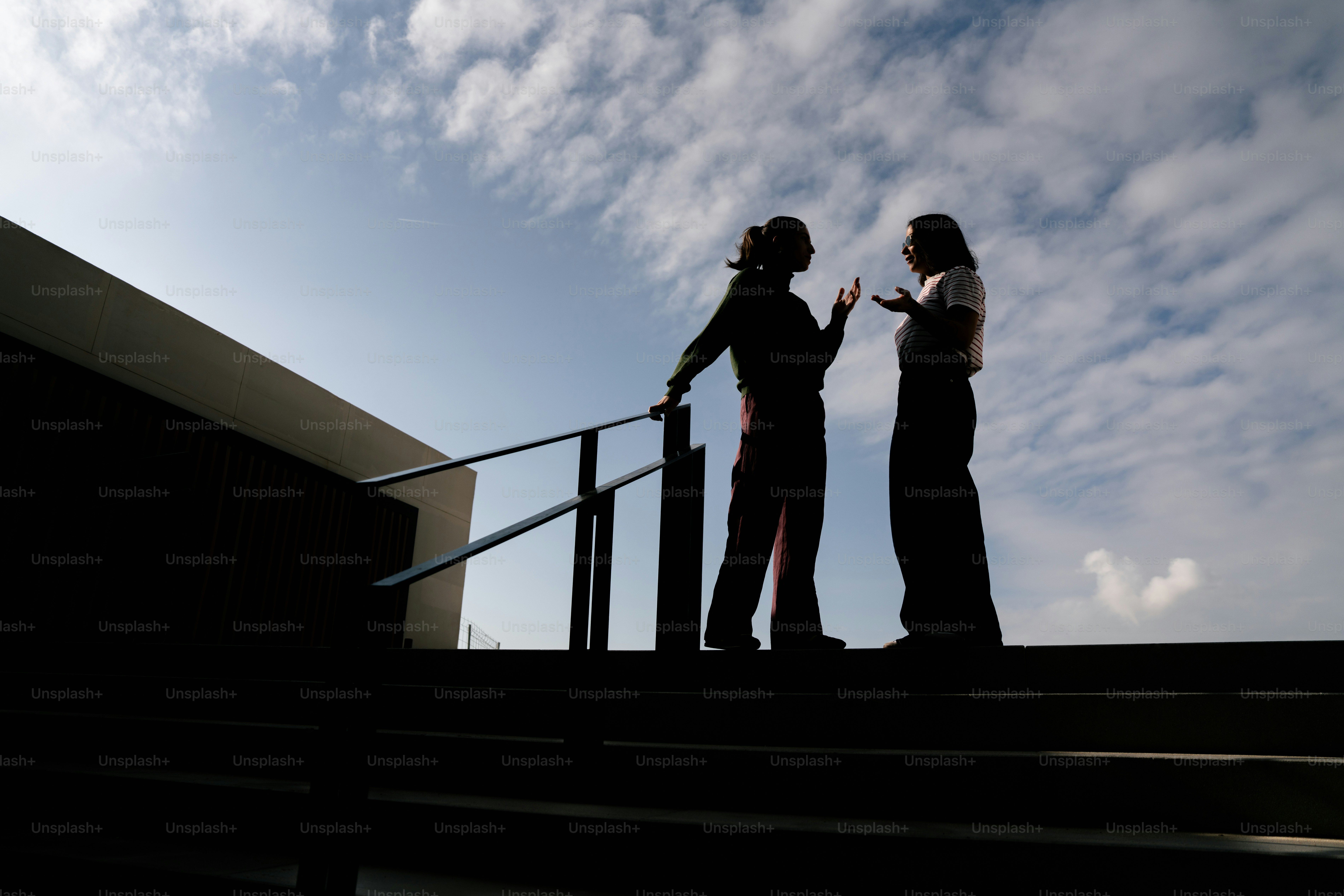 흐린 하늘 아래 계단에서 이야기하는 두 사람