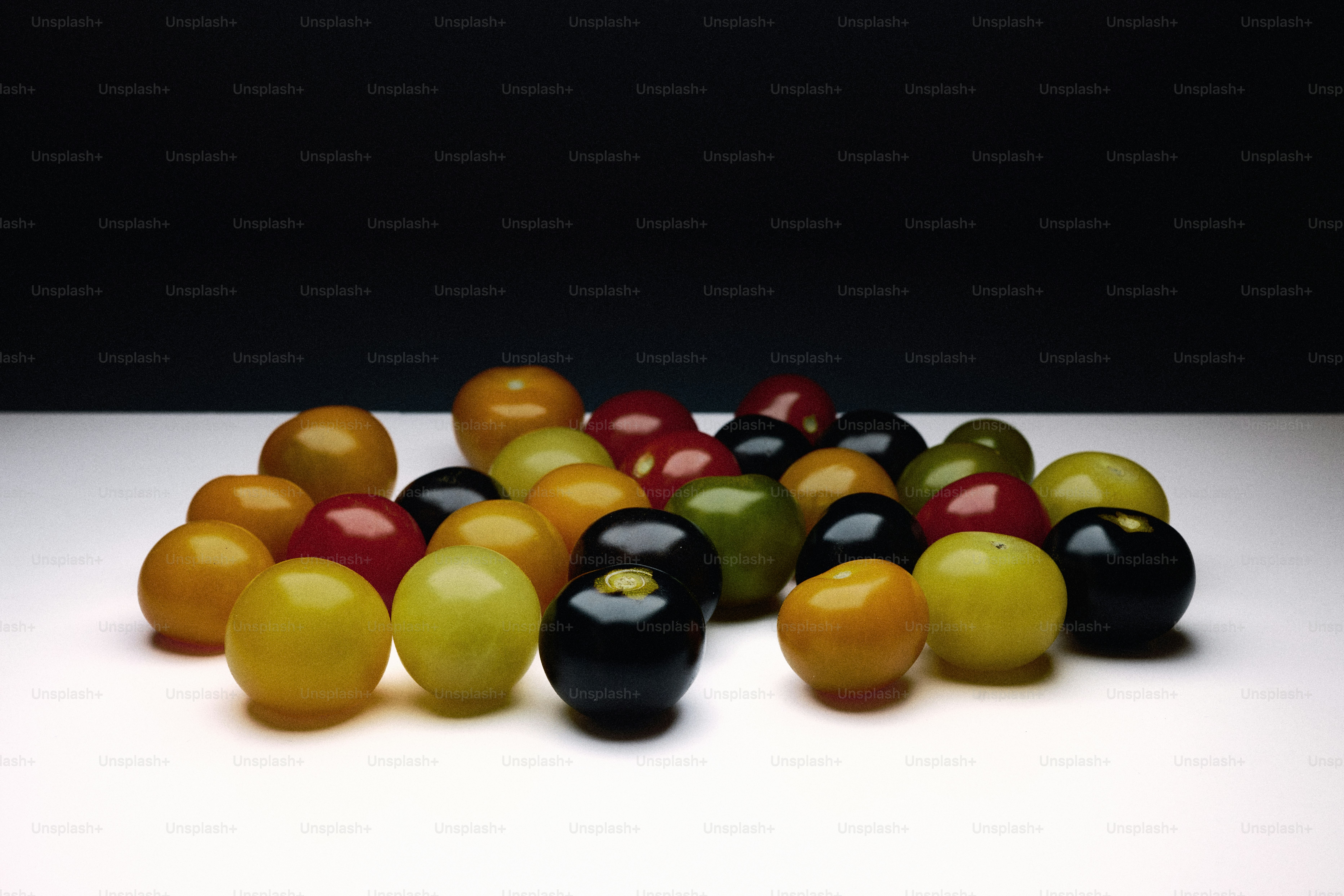 Un montón de canicas de colores sobre una superficie blanca