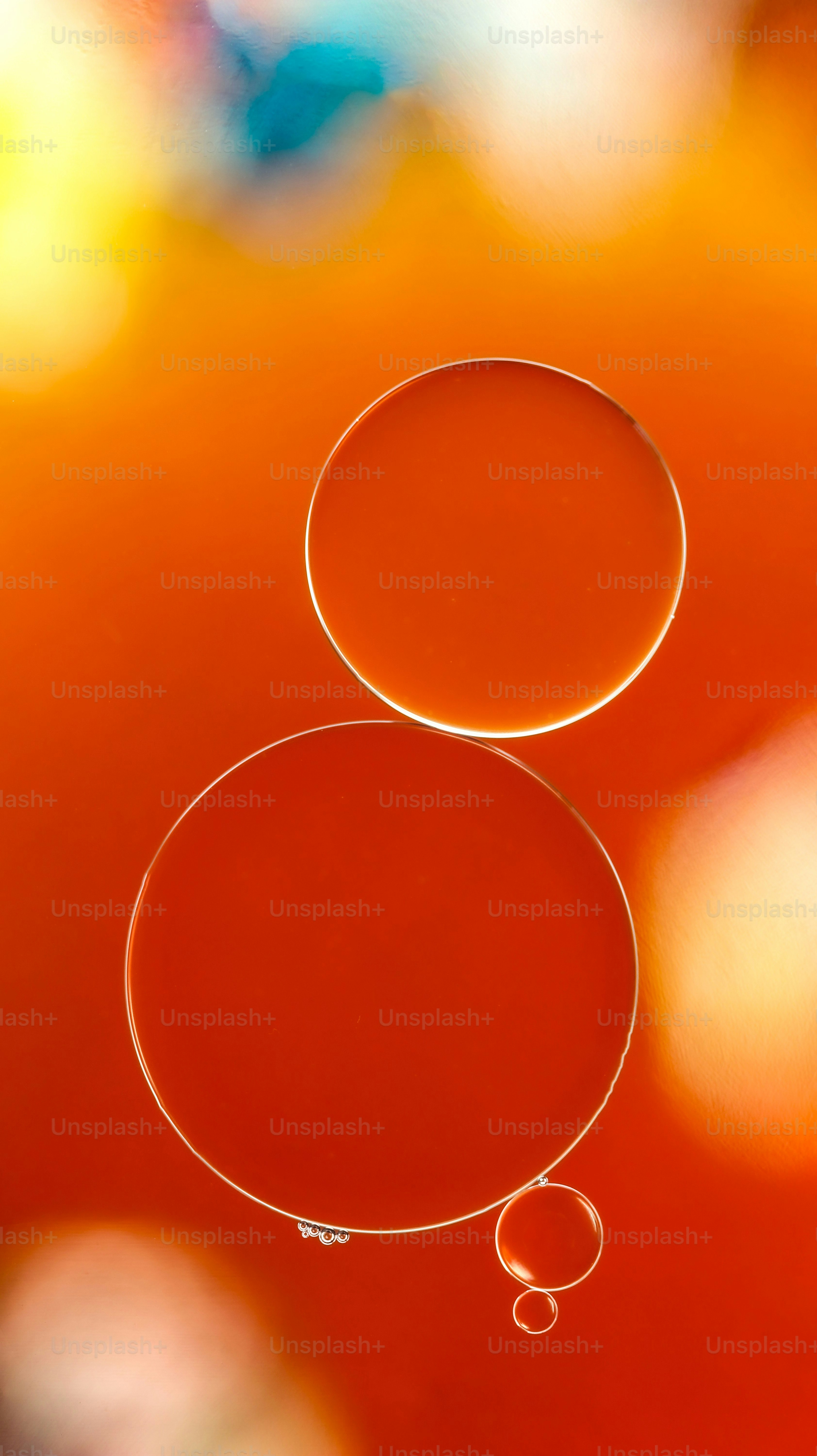 Orange and red oil bubbles with blurred colorful background
