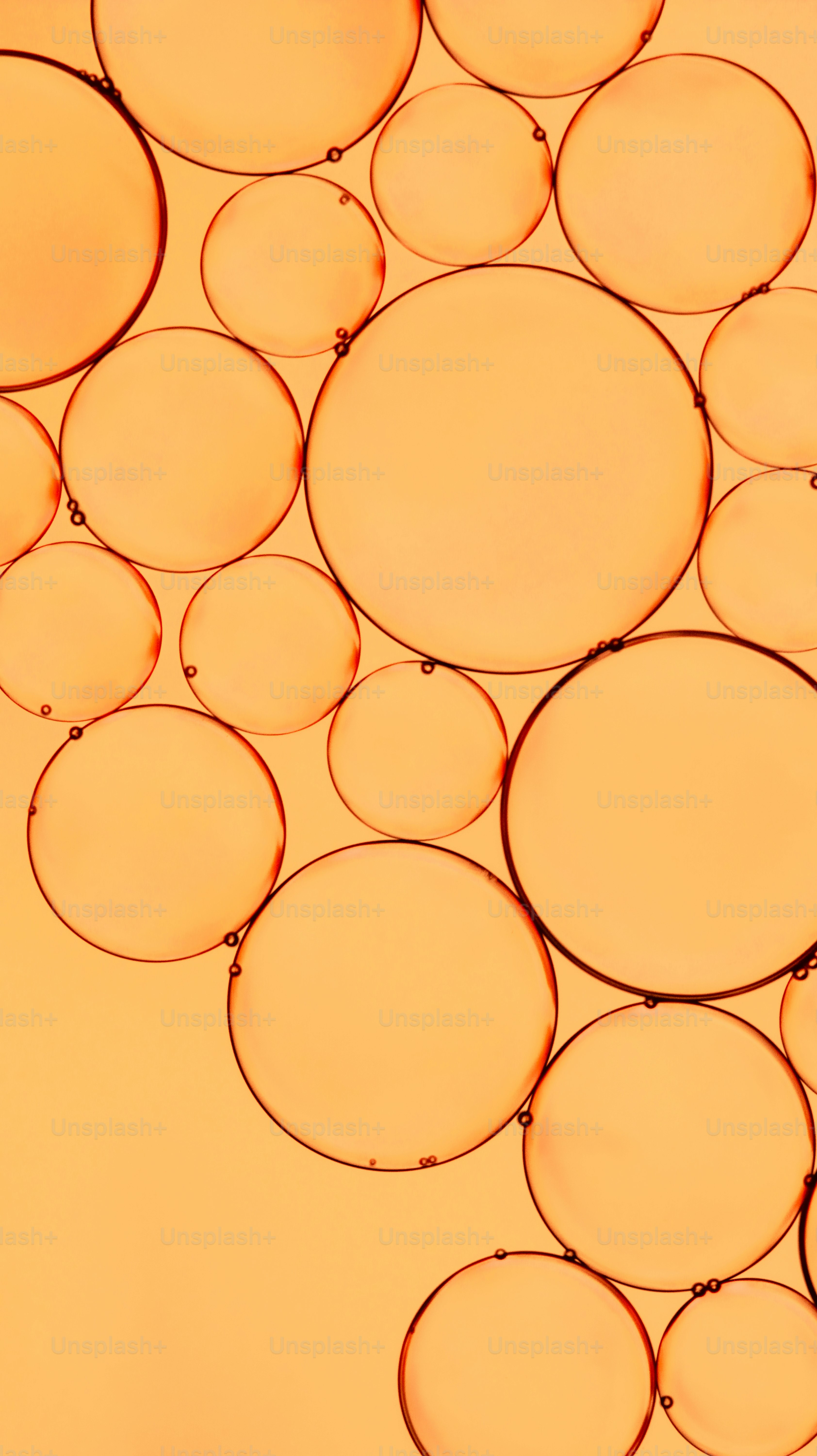 Close-up of orange oil bubbles on a light orange background