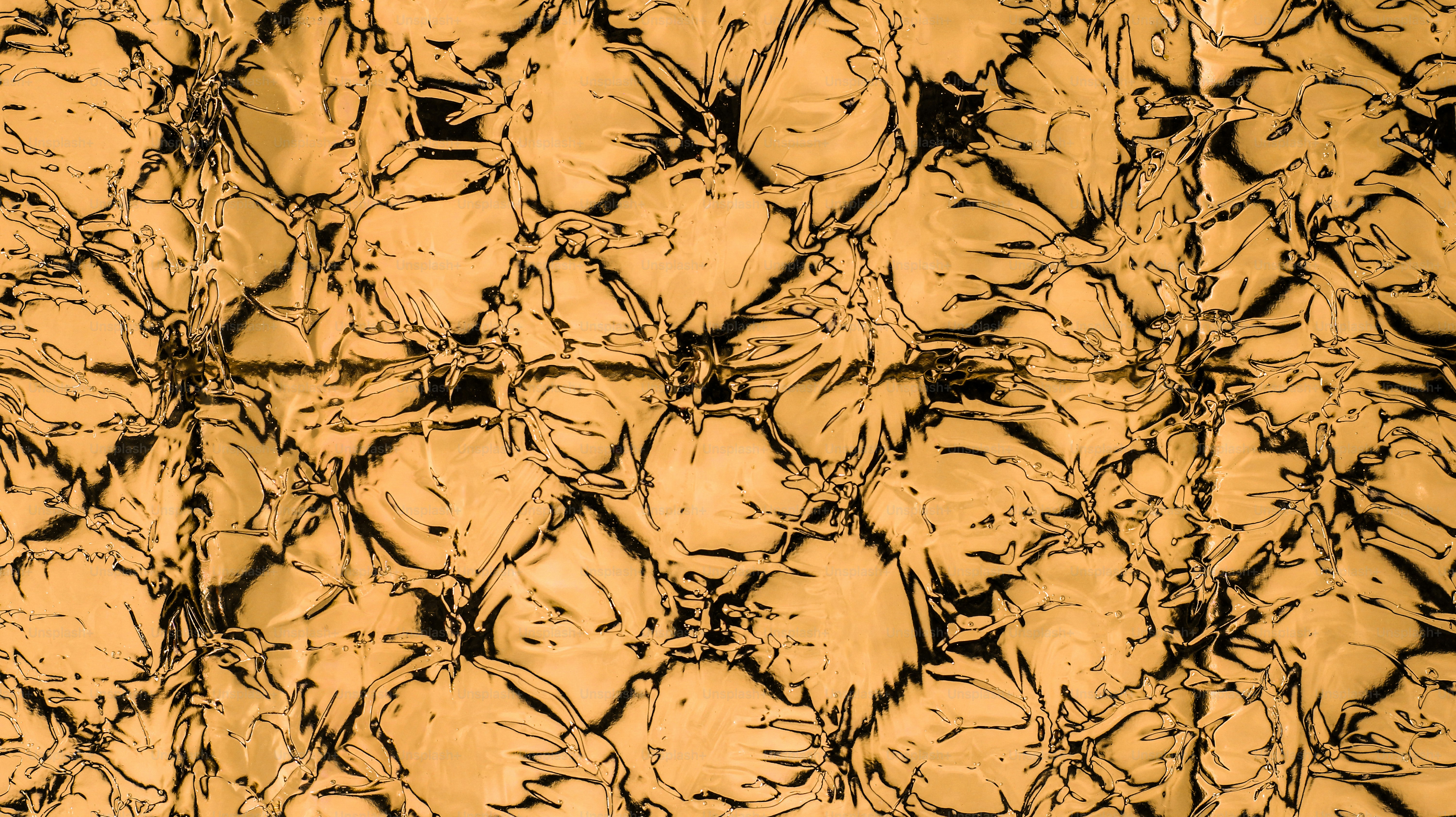 Primo piano di una superficie dorata testurizzata con motivi scuri