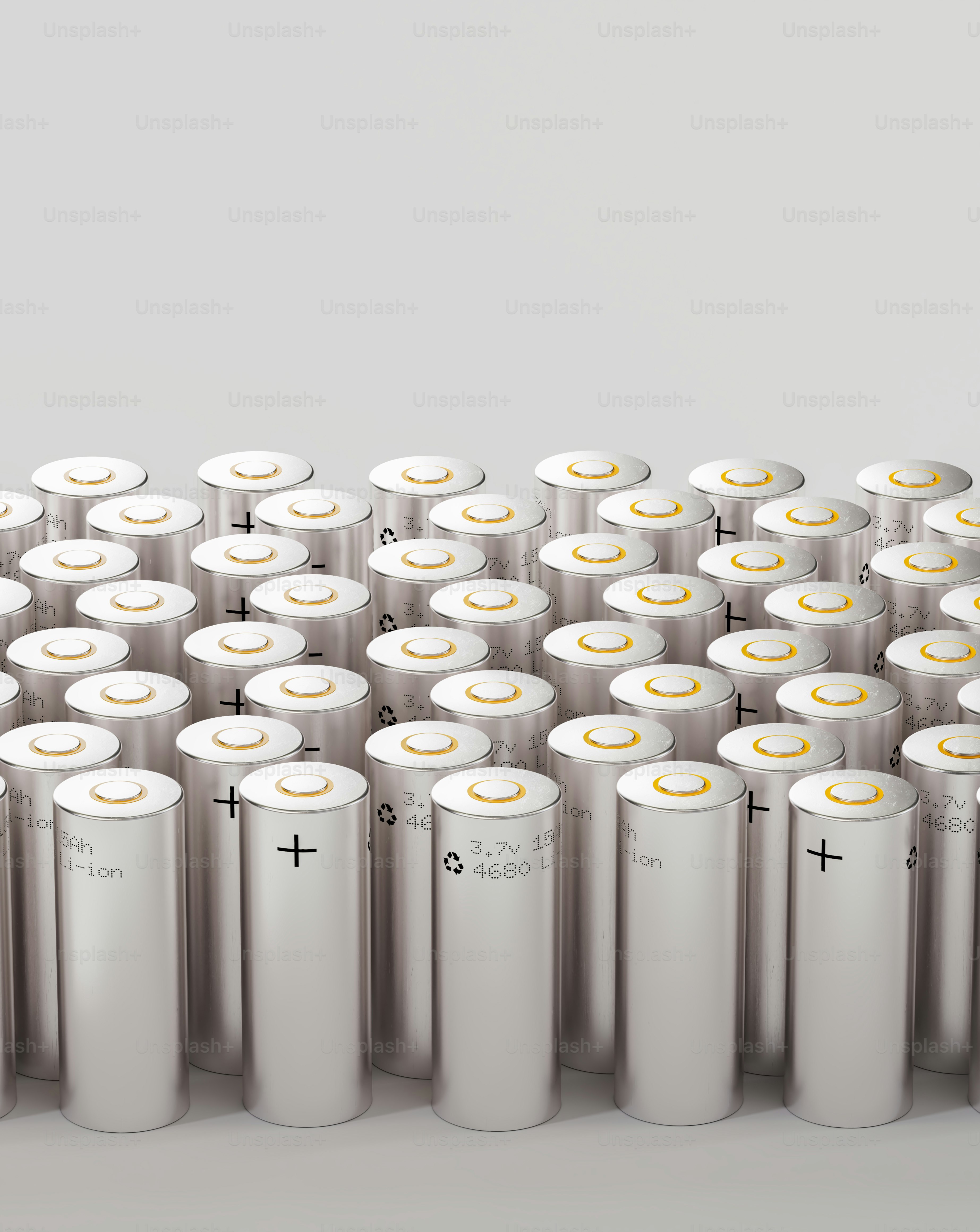 많은 은색 배터리들이 흰 표면 위에 줄지어 배치되어 있었다.