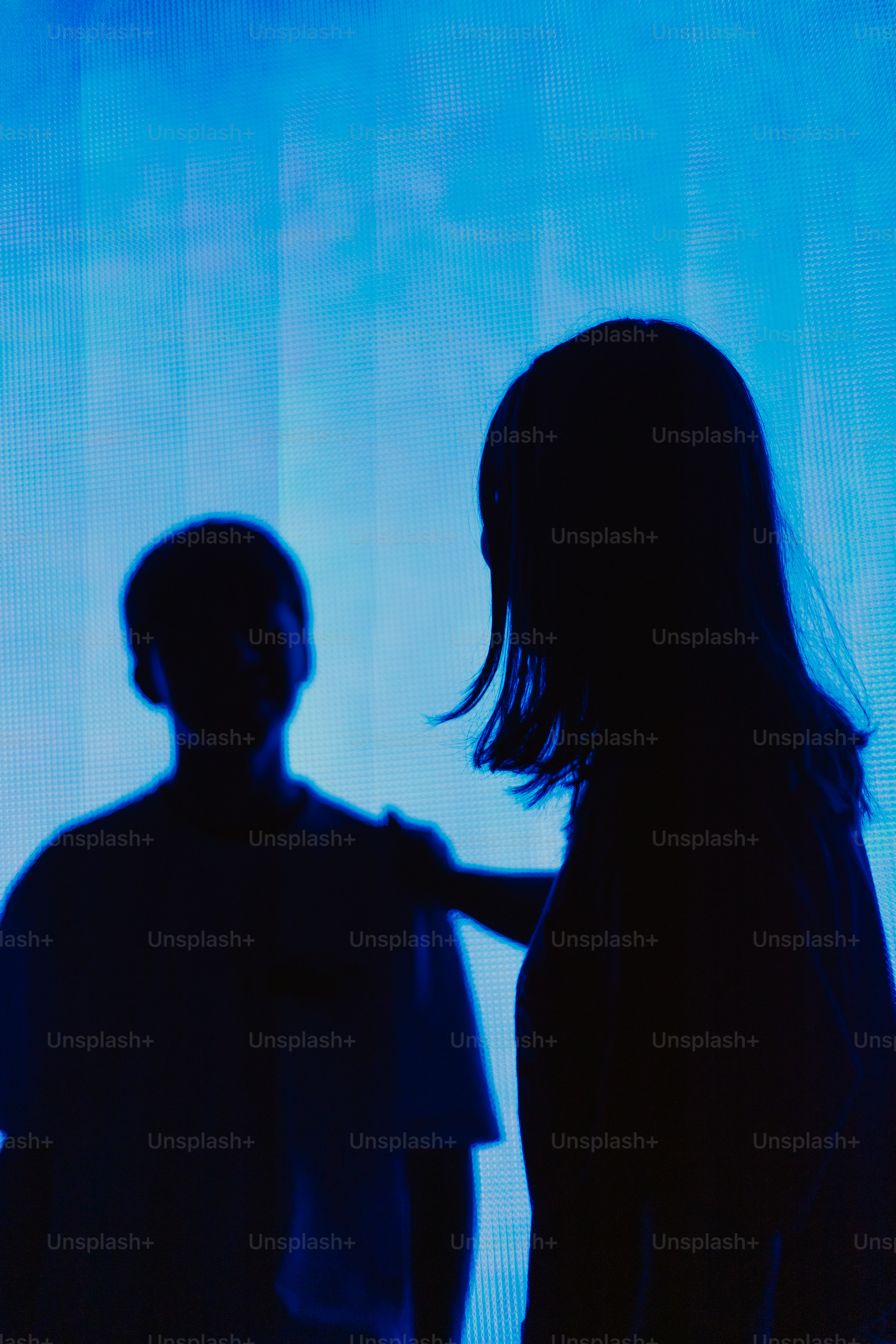 Two silhouettes against a blue background