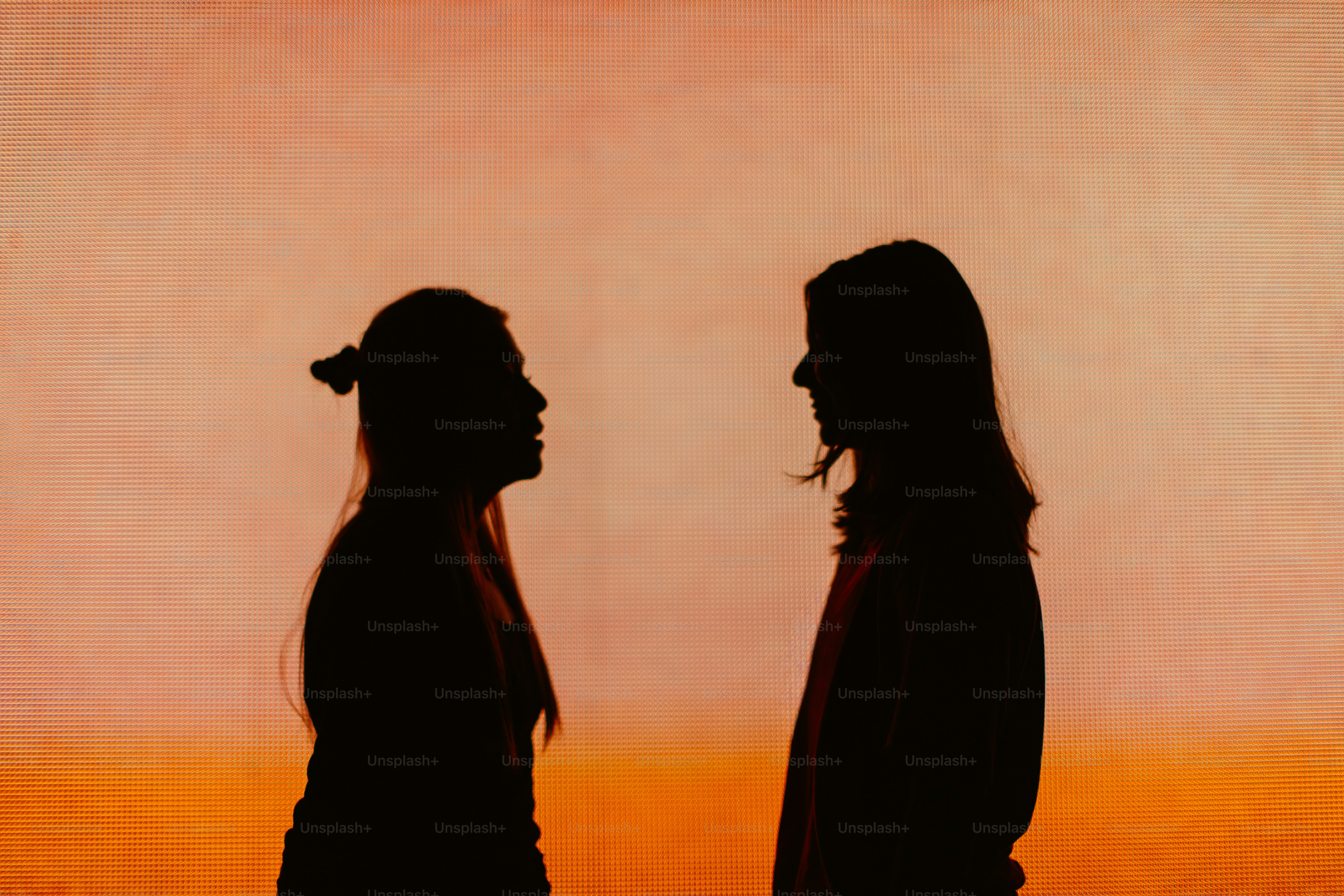 Two people silhouetted against a vibrant sunset