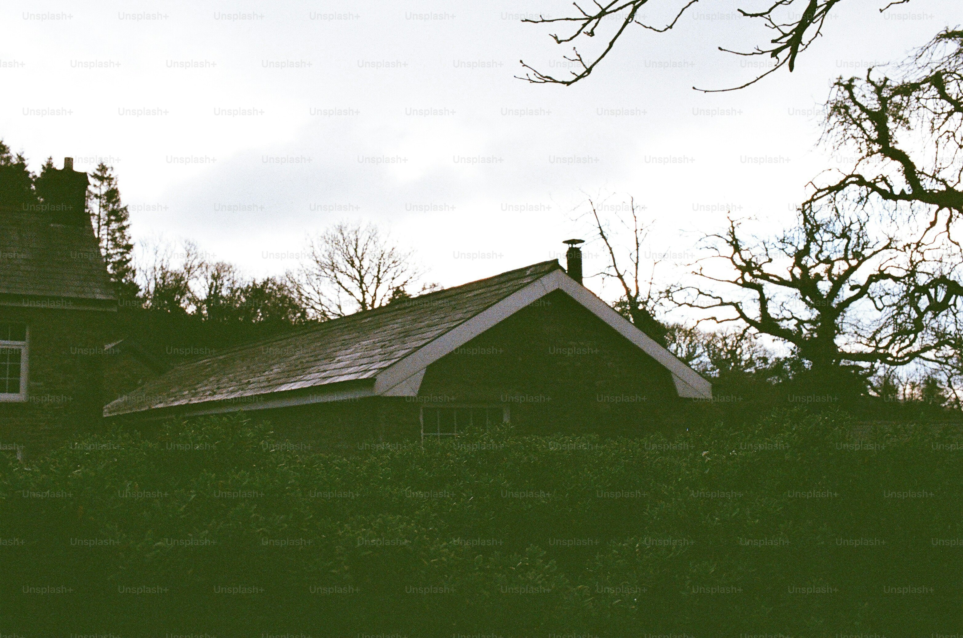 Ein dunkles, niedrig gelegenes Gebäude mit Schornstein.
