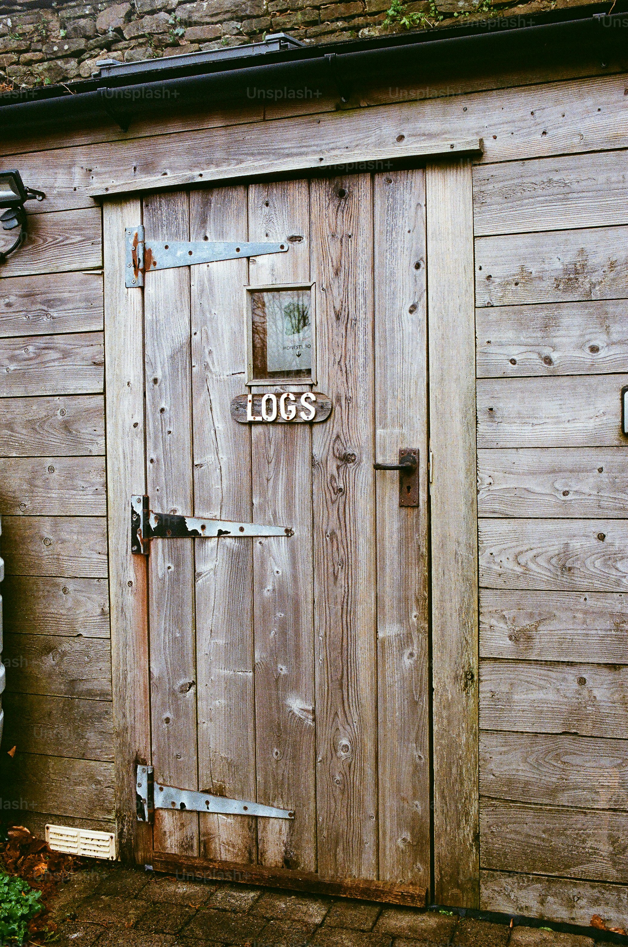 Rustic wooden door with a sign that says logs