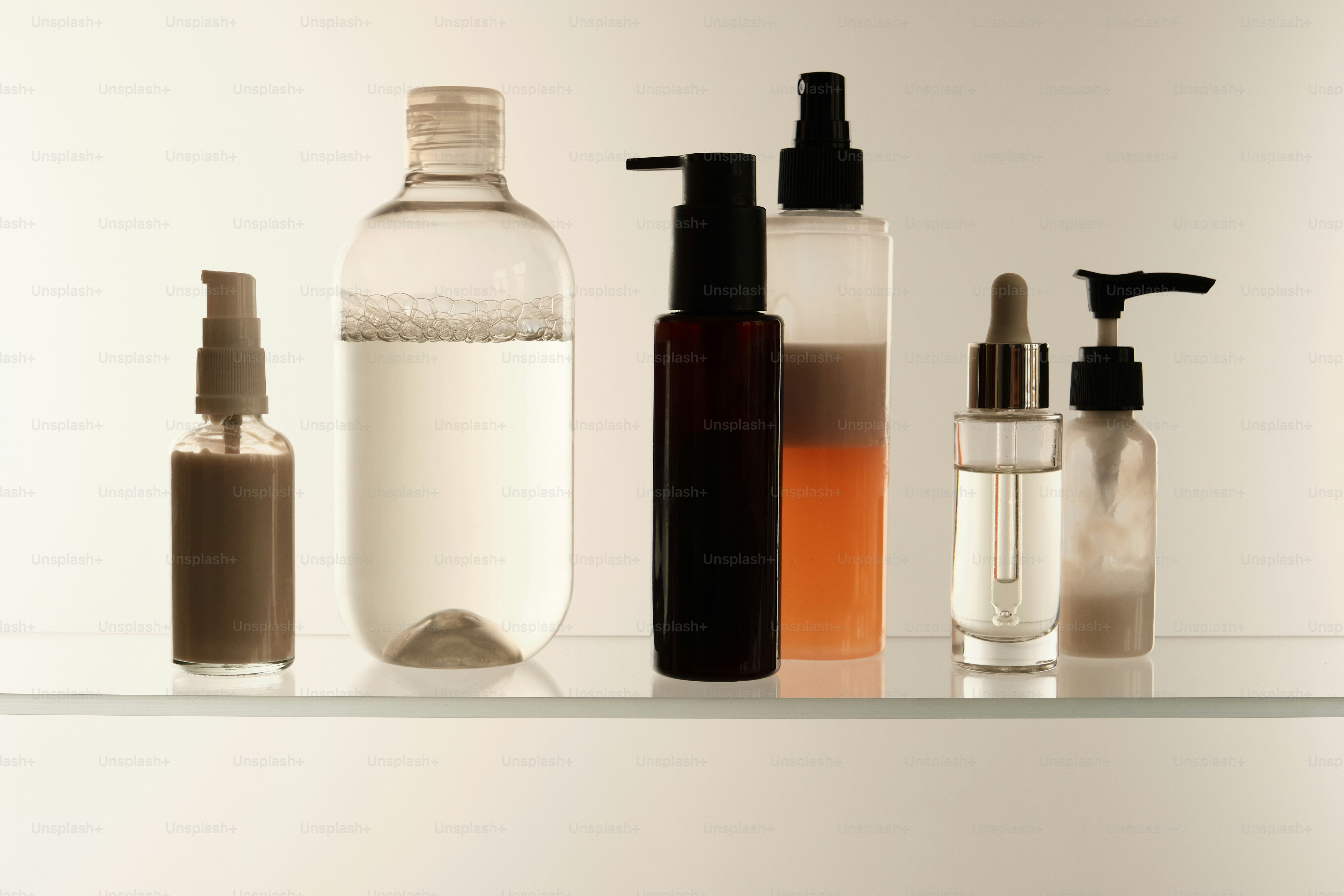Various cosmetic bottles arranged on a shelf.