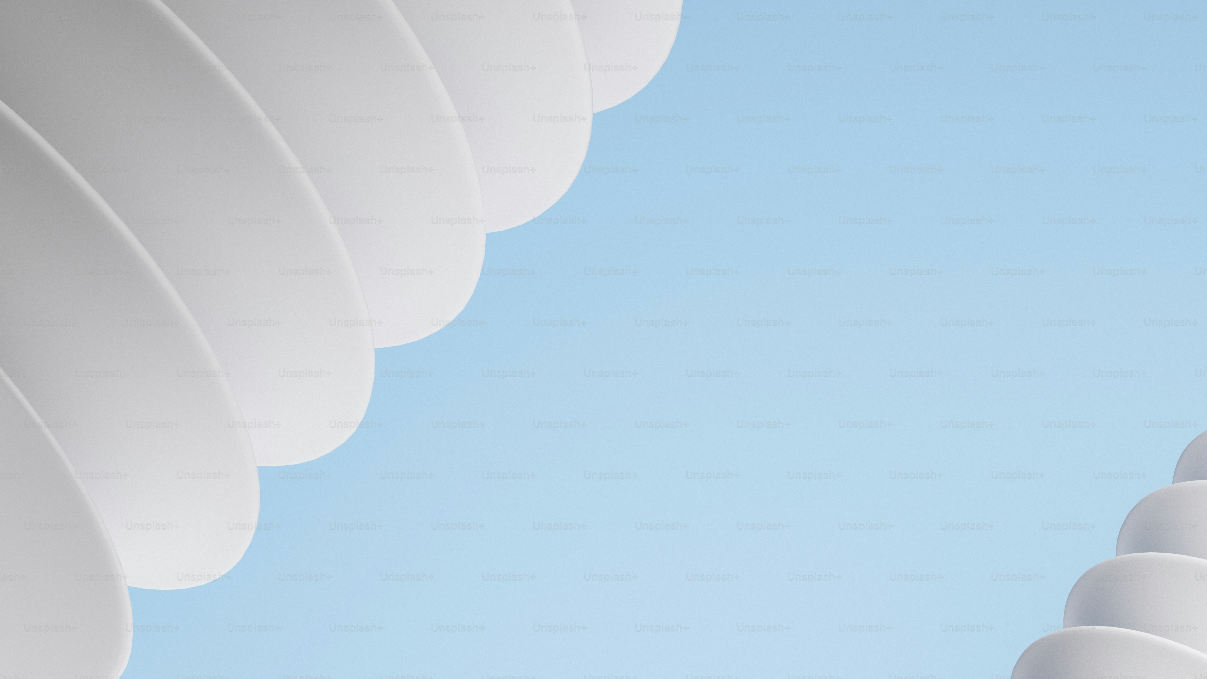 Des formes blanches abstraites superposées sur un ciel bleu.