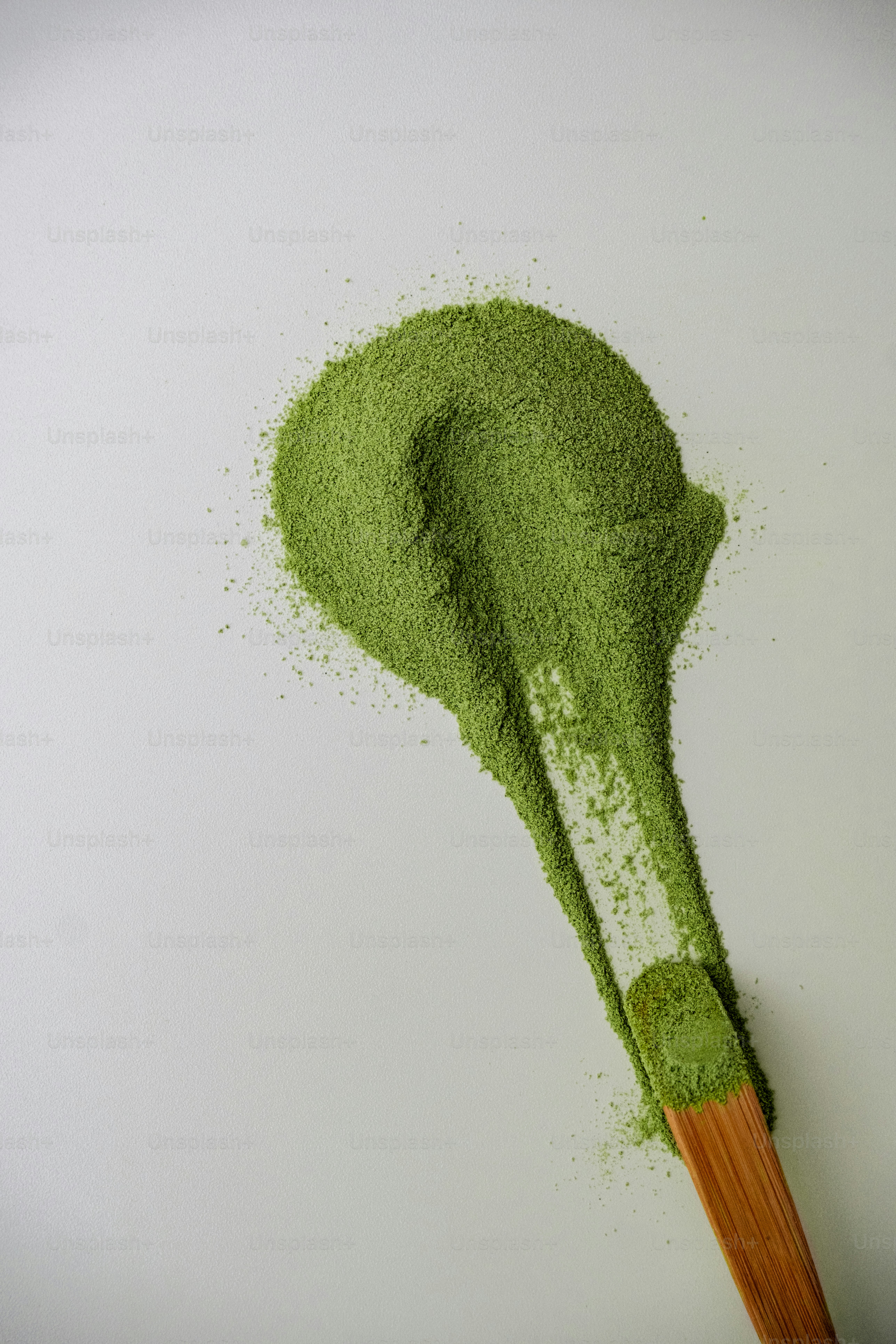 Green powder on a wooden spoon
