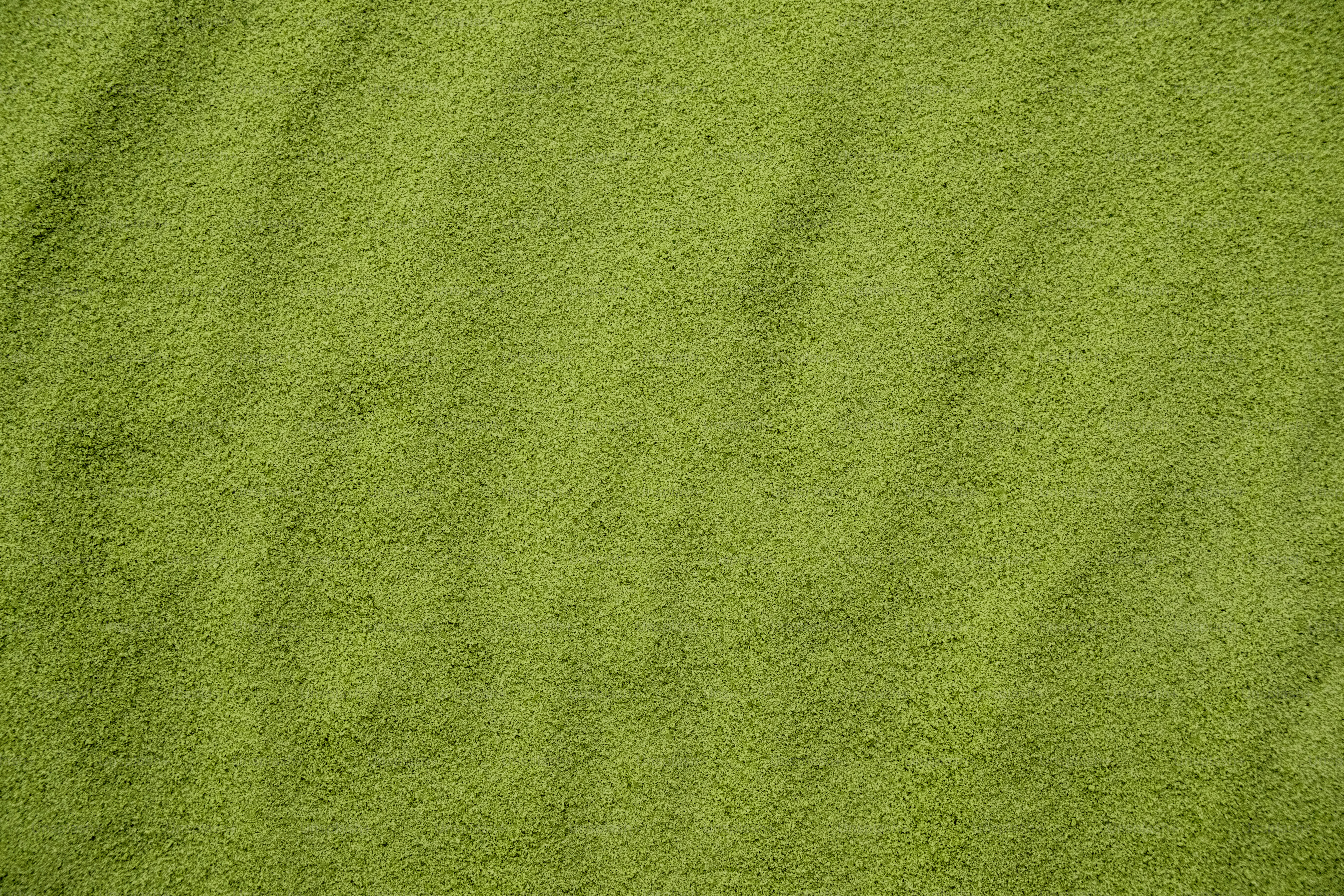 A textured green fabric surface with subtle folds