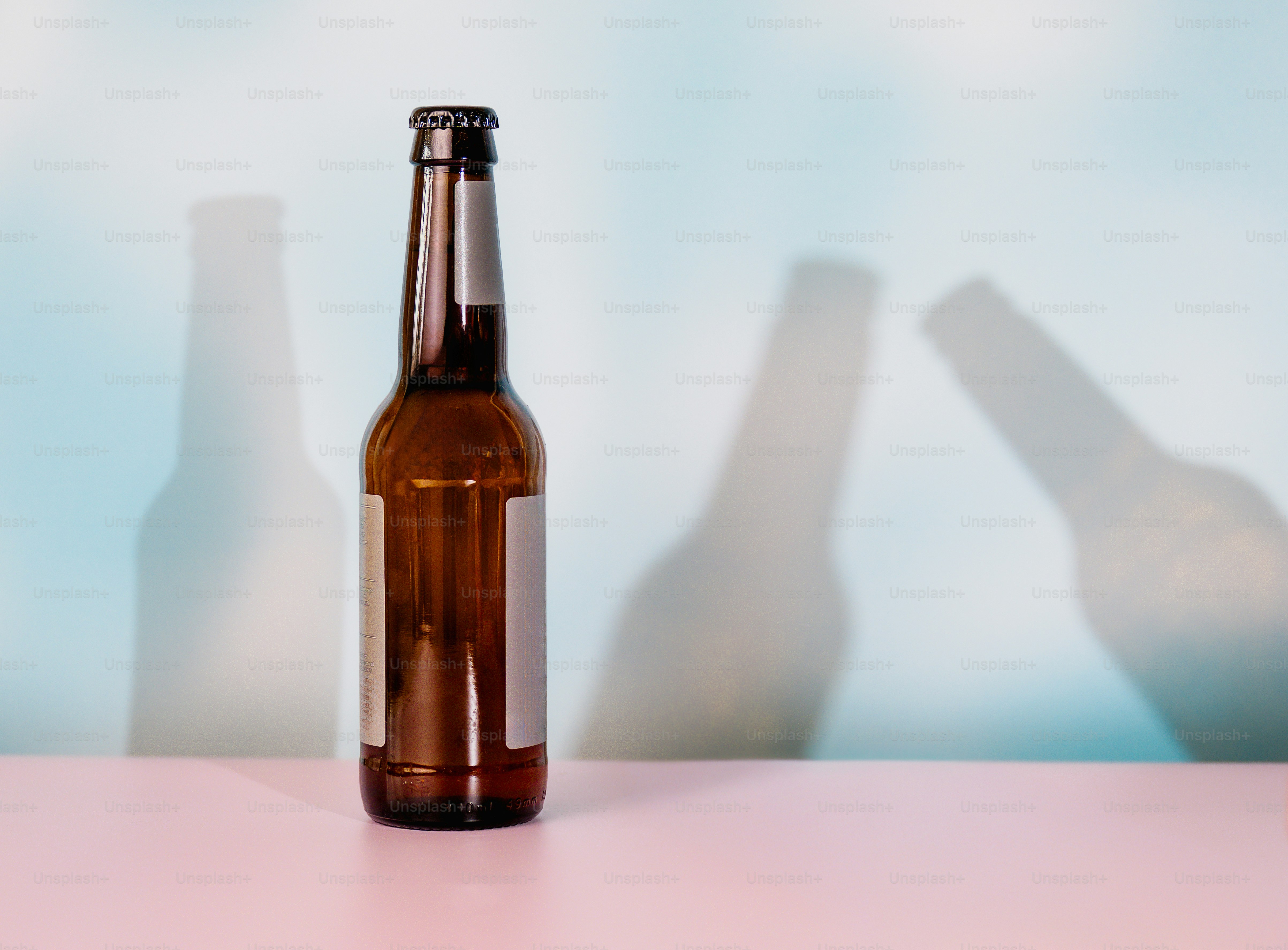 Bouteille en verre brun projetant des ombres sur le mur bleu