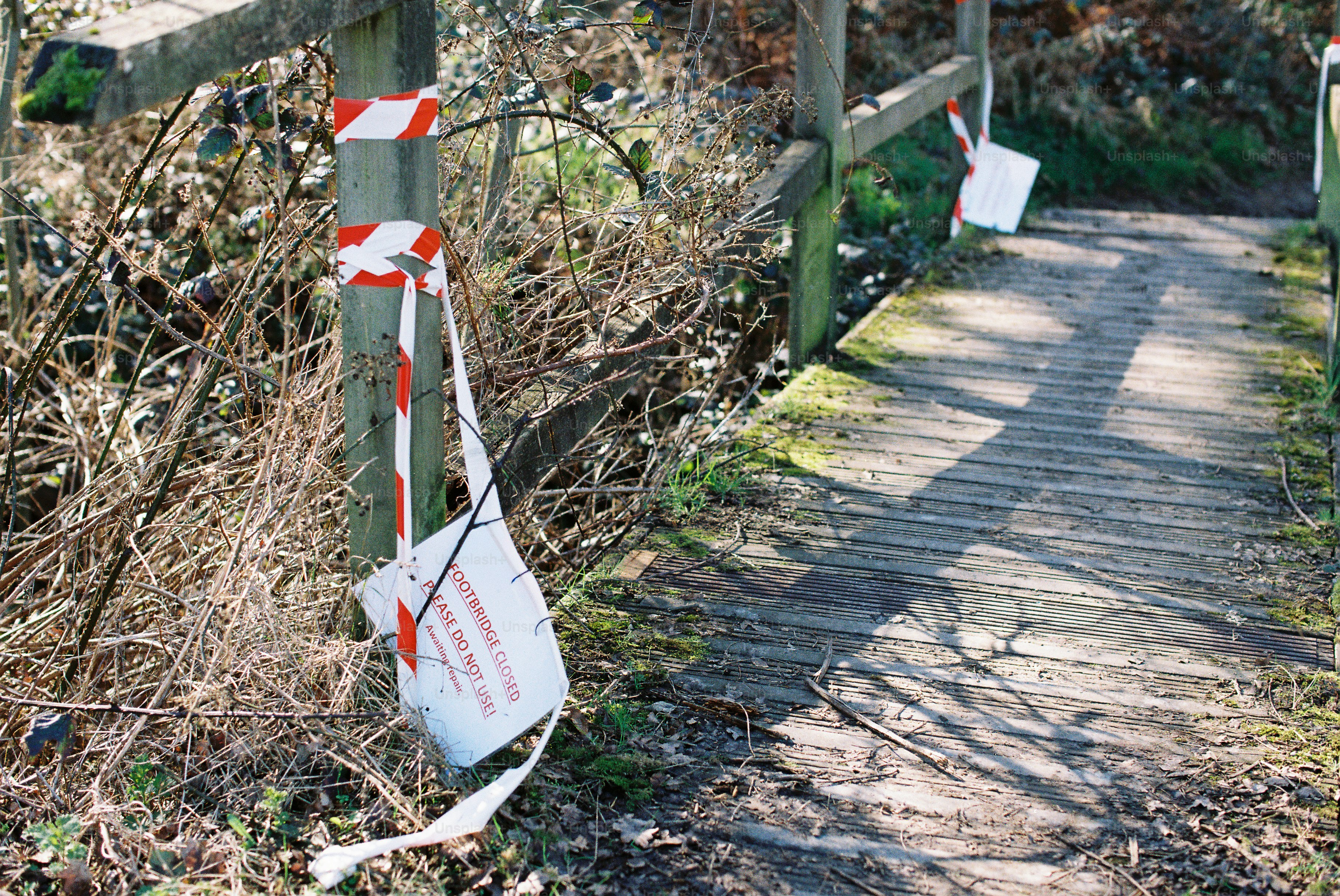 Wooden bridge with caution tape and signs