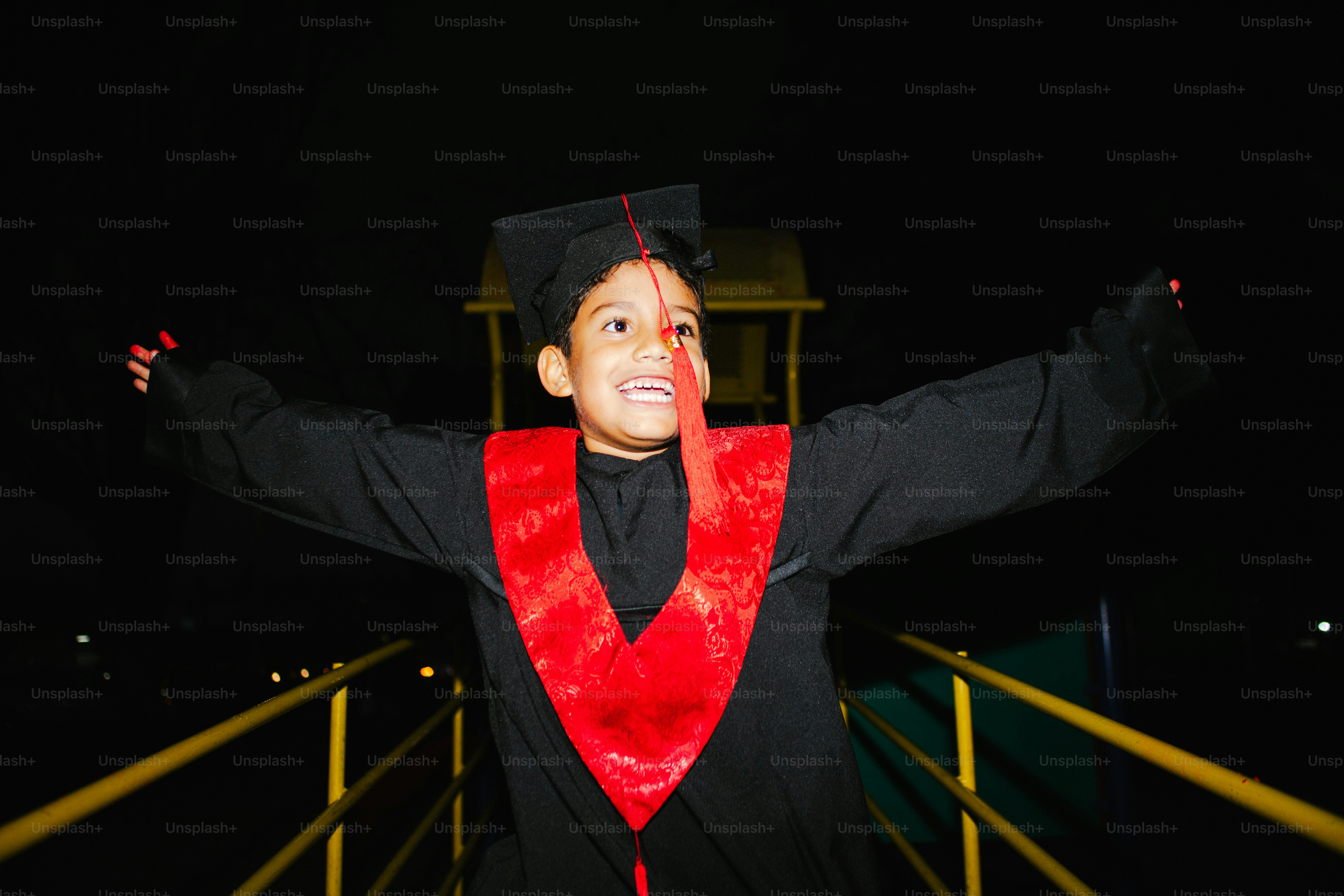 A graduate in cap and gown celebrates with confetti. photo – Portrait ...