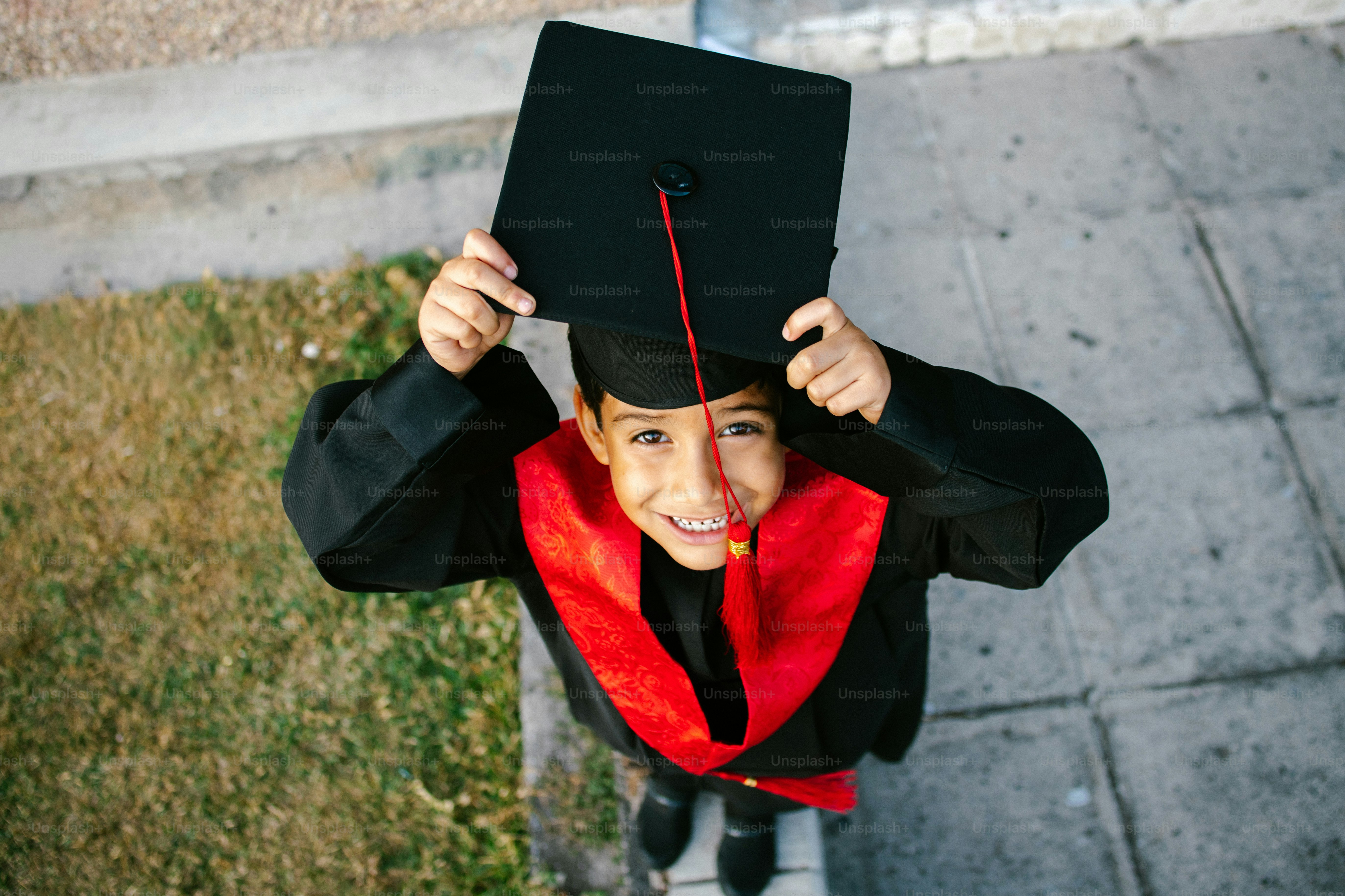 A graduate in cap and gown celebrates with confetti. photo – Portrait ...