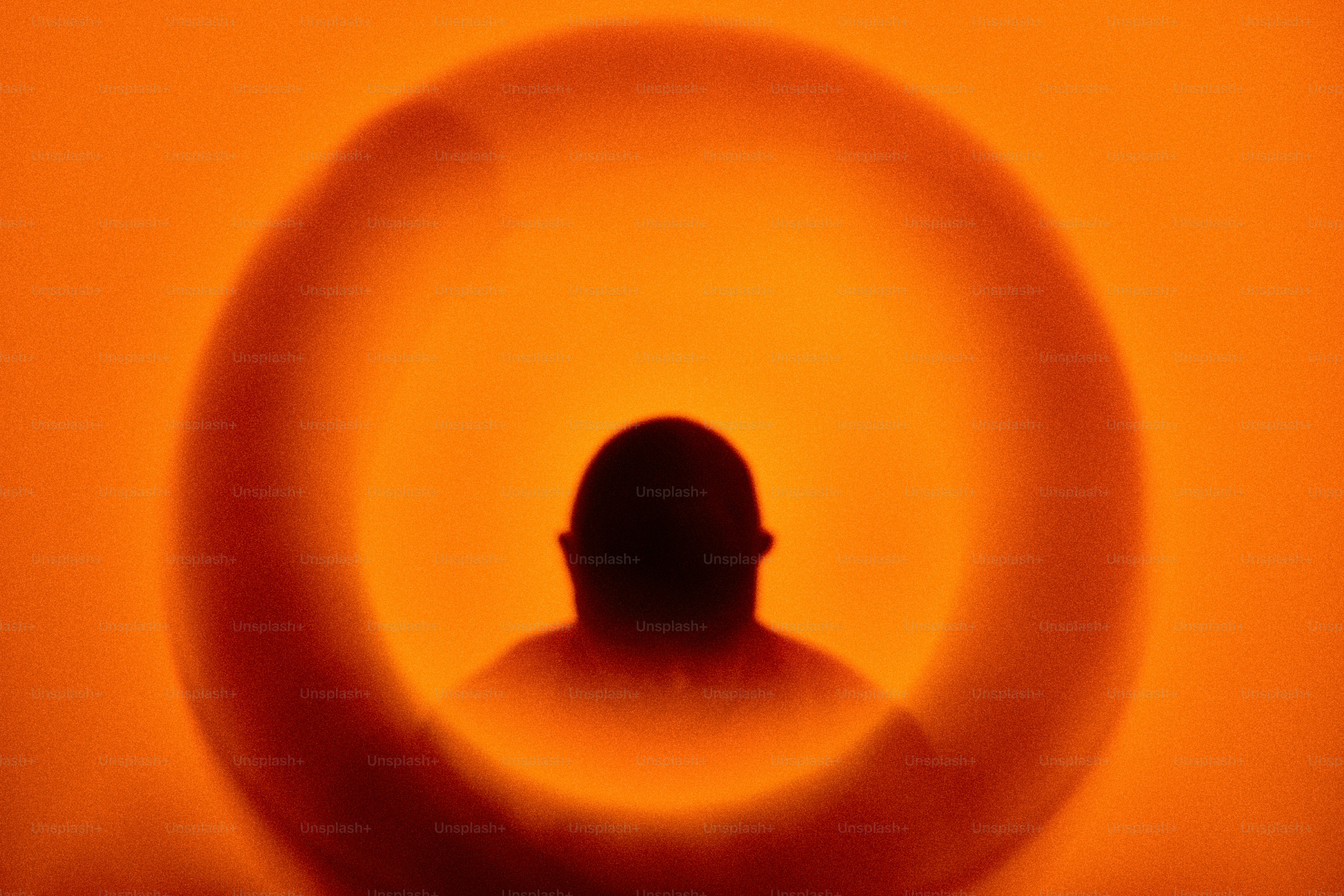 Silhouette of a person seen through an orange ring