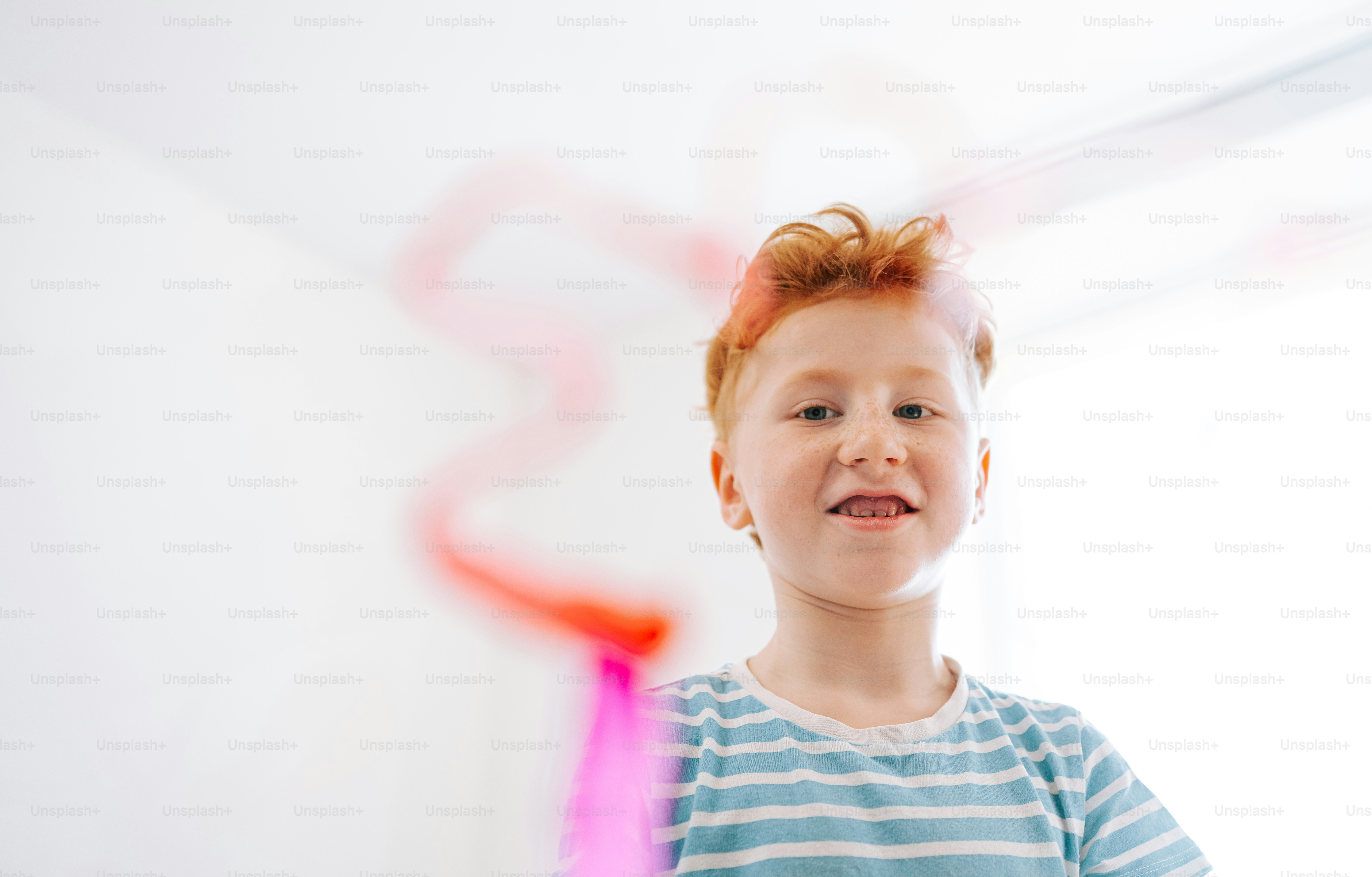 A young boy with red hair smiles