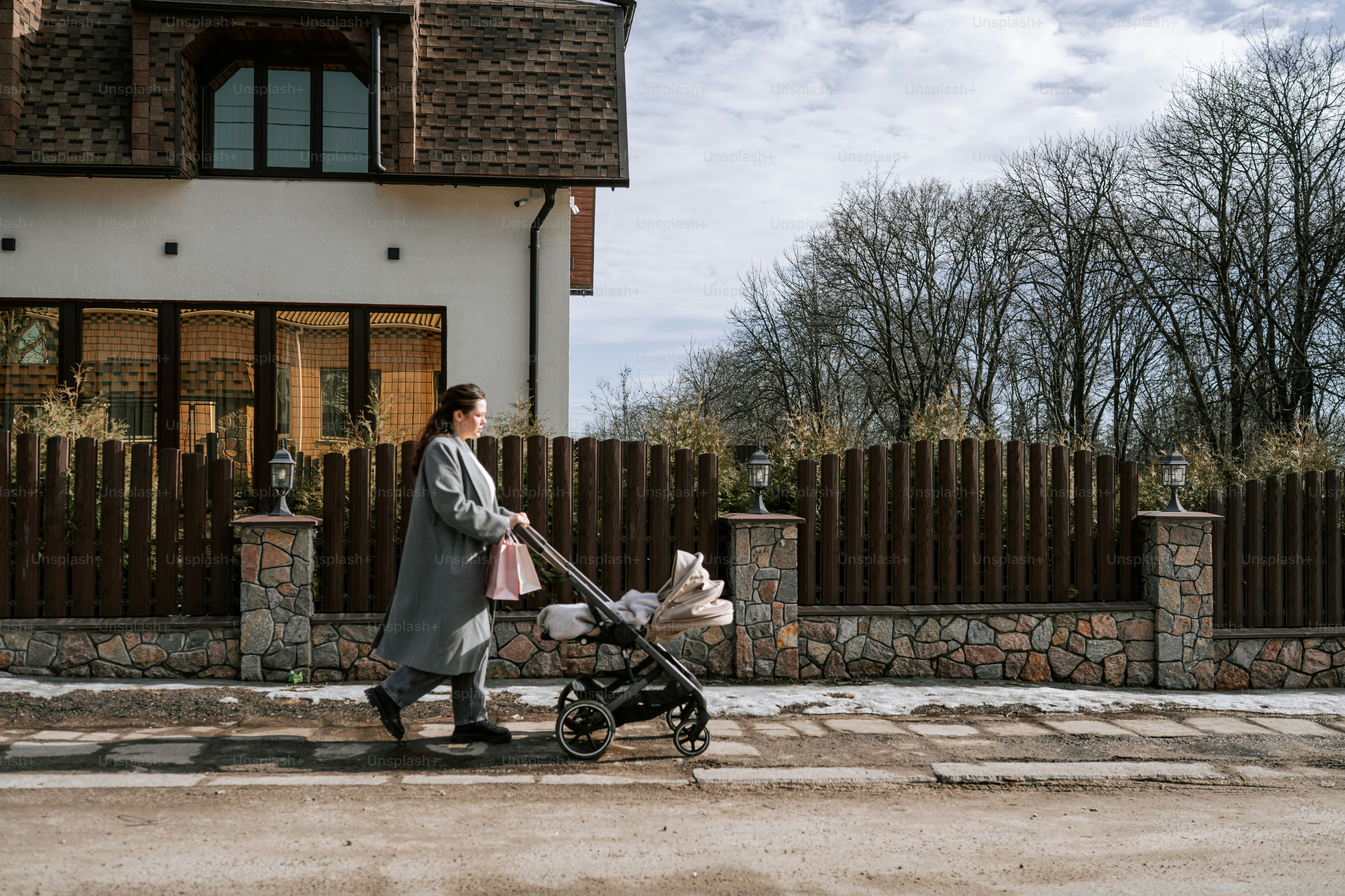 Woman pushing a stroller down a sidewalk.