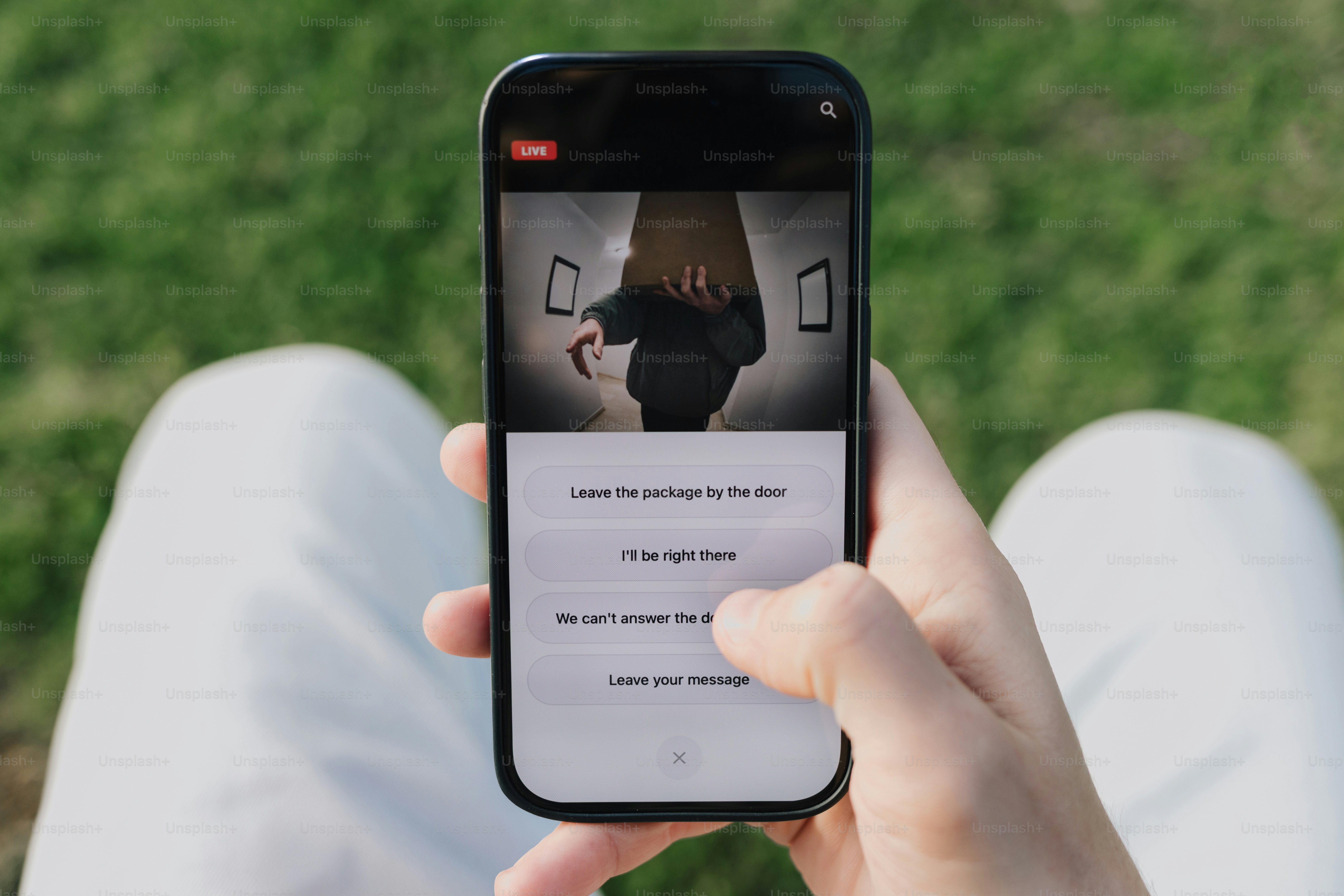 Person using smartphone to view security camera feed.