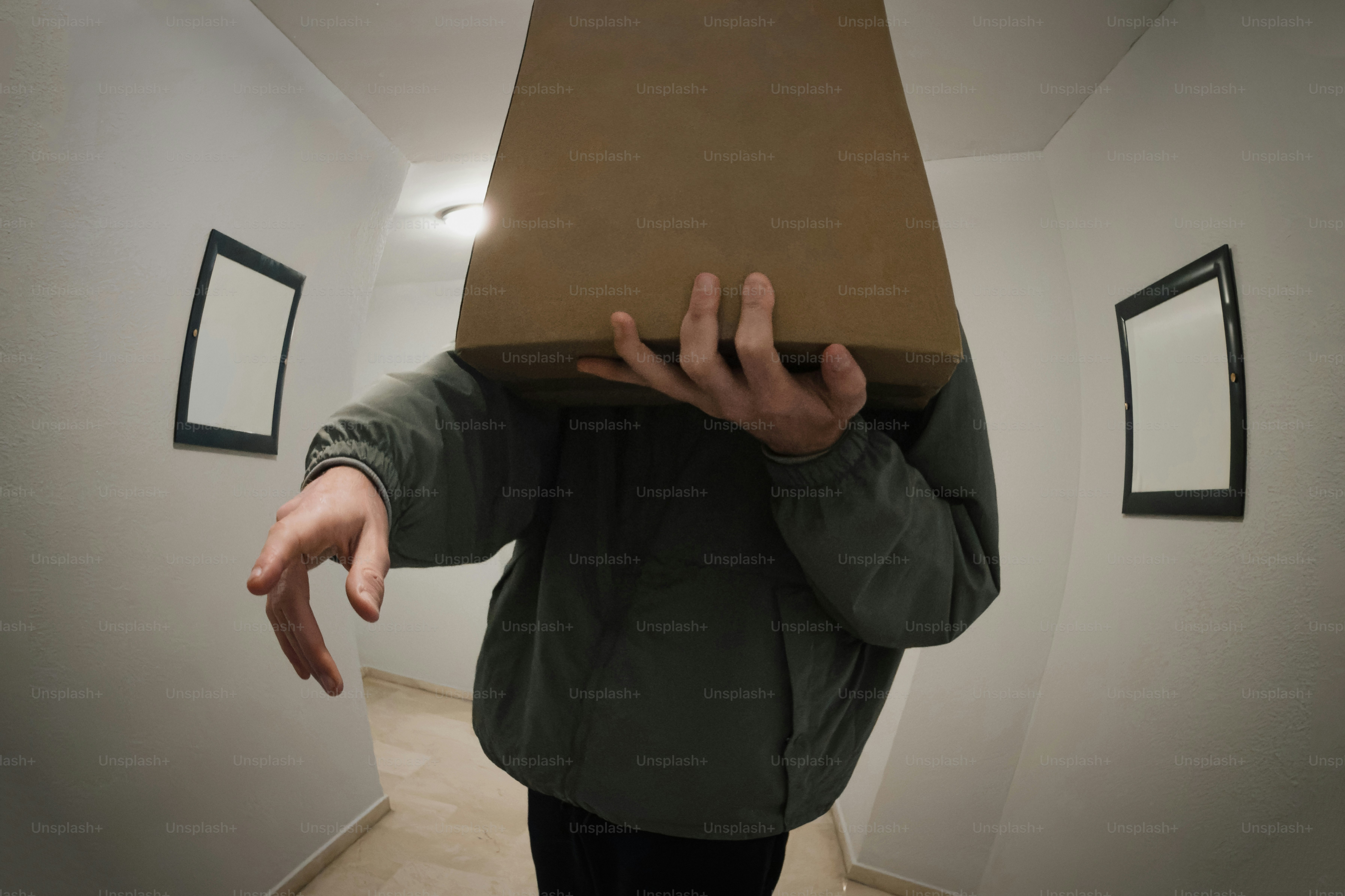 Person holding a cardboard box over their head