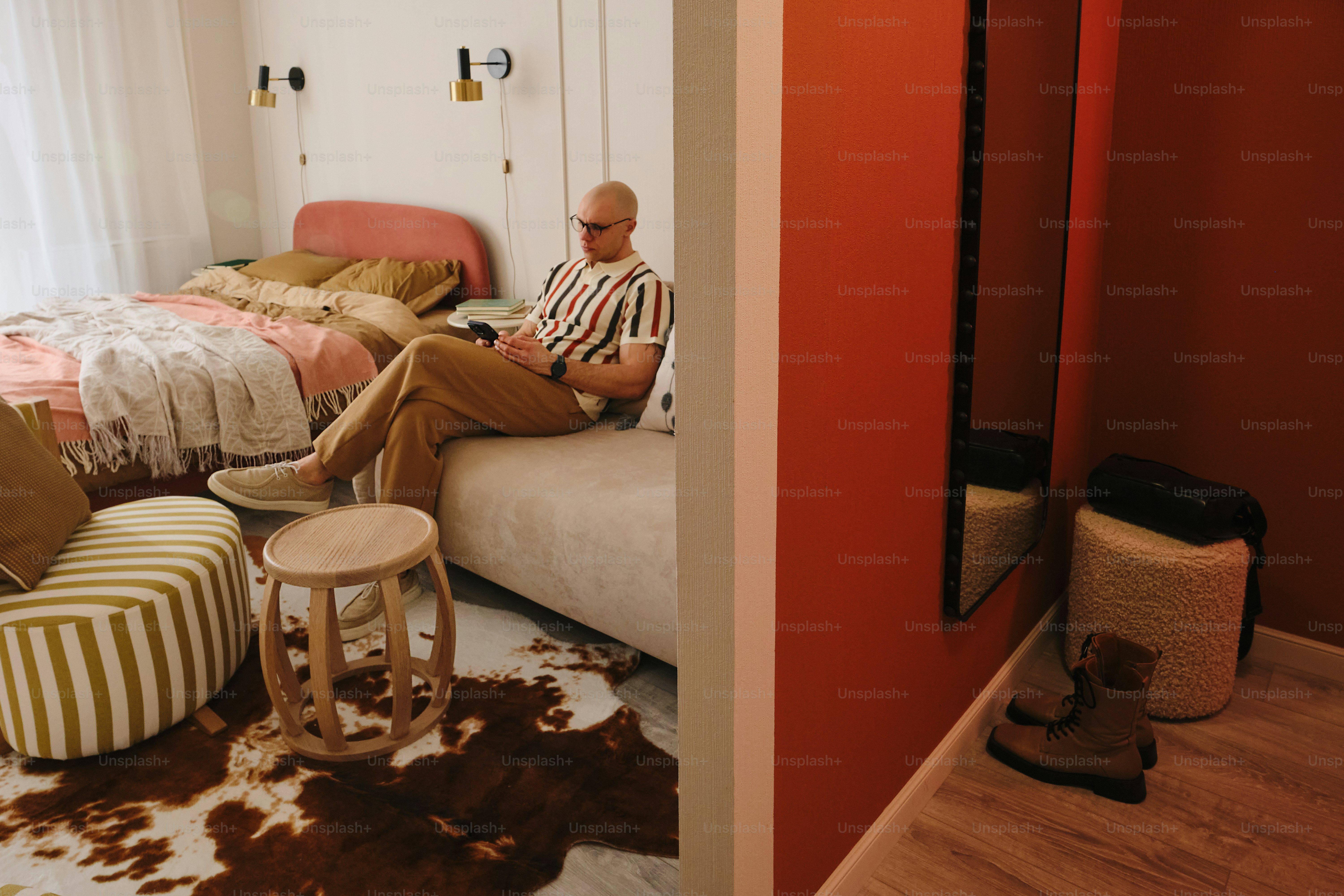 Man sitting on a bed in a stylish room.