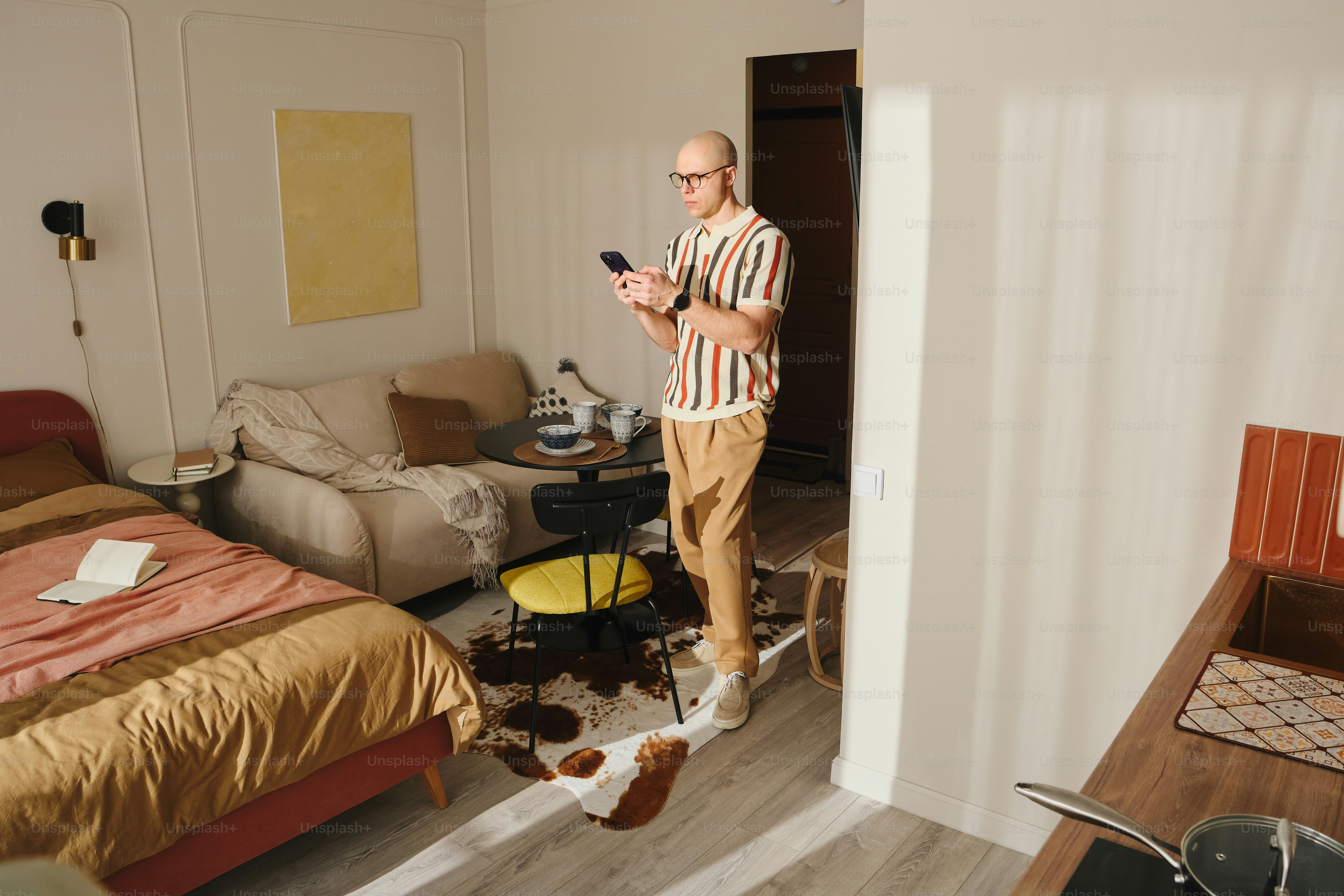 Man looking at phone near spilled drink on floor.