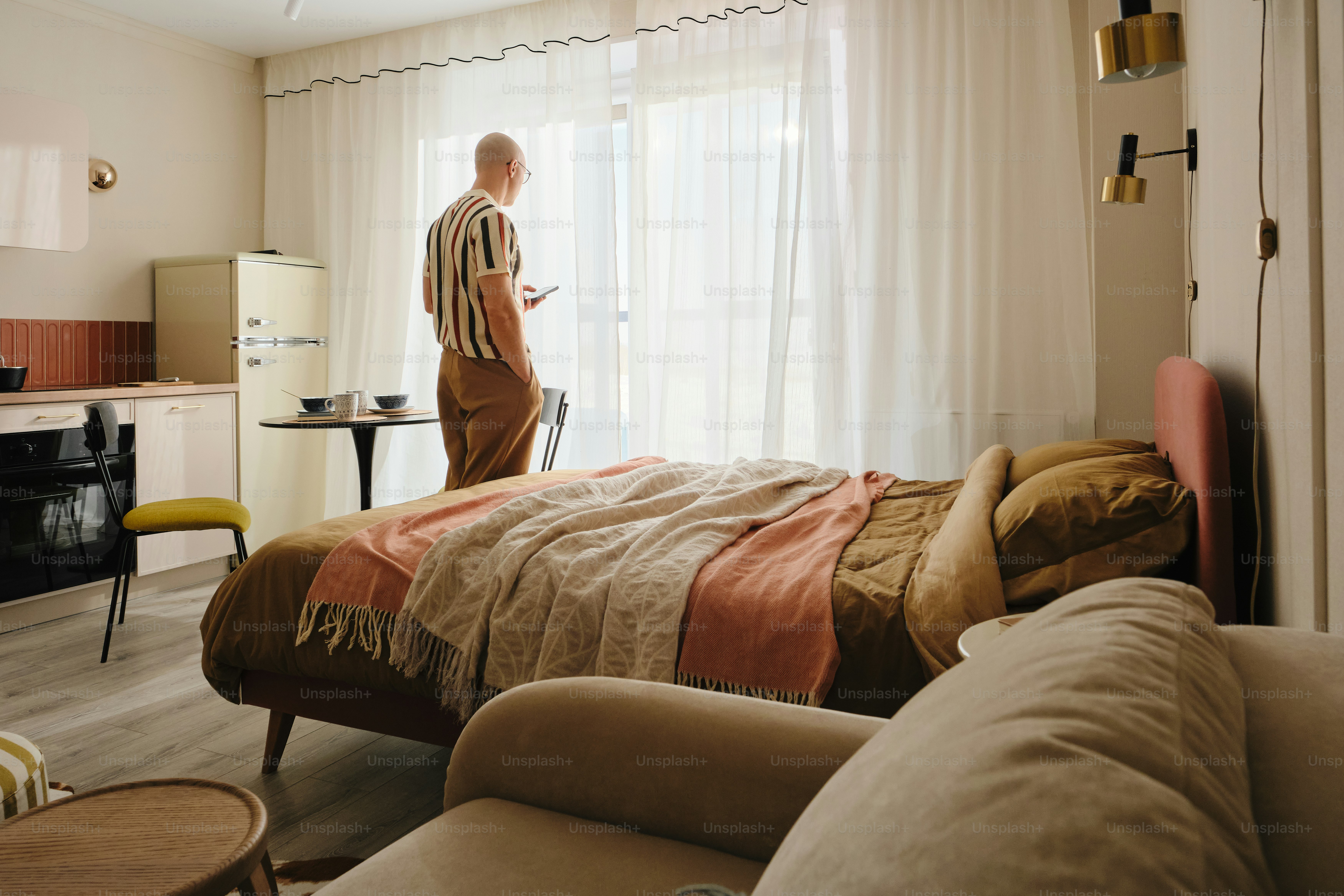 Man standing by window in a studio apartment