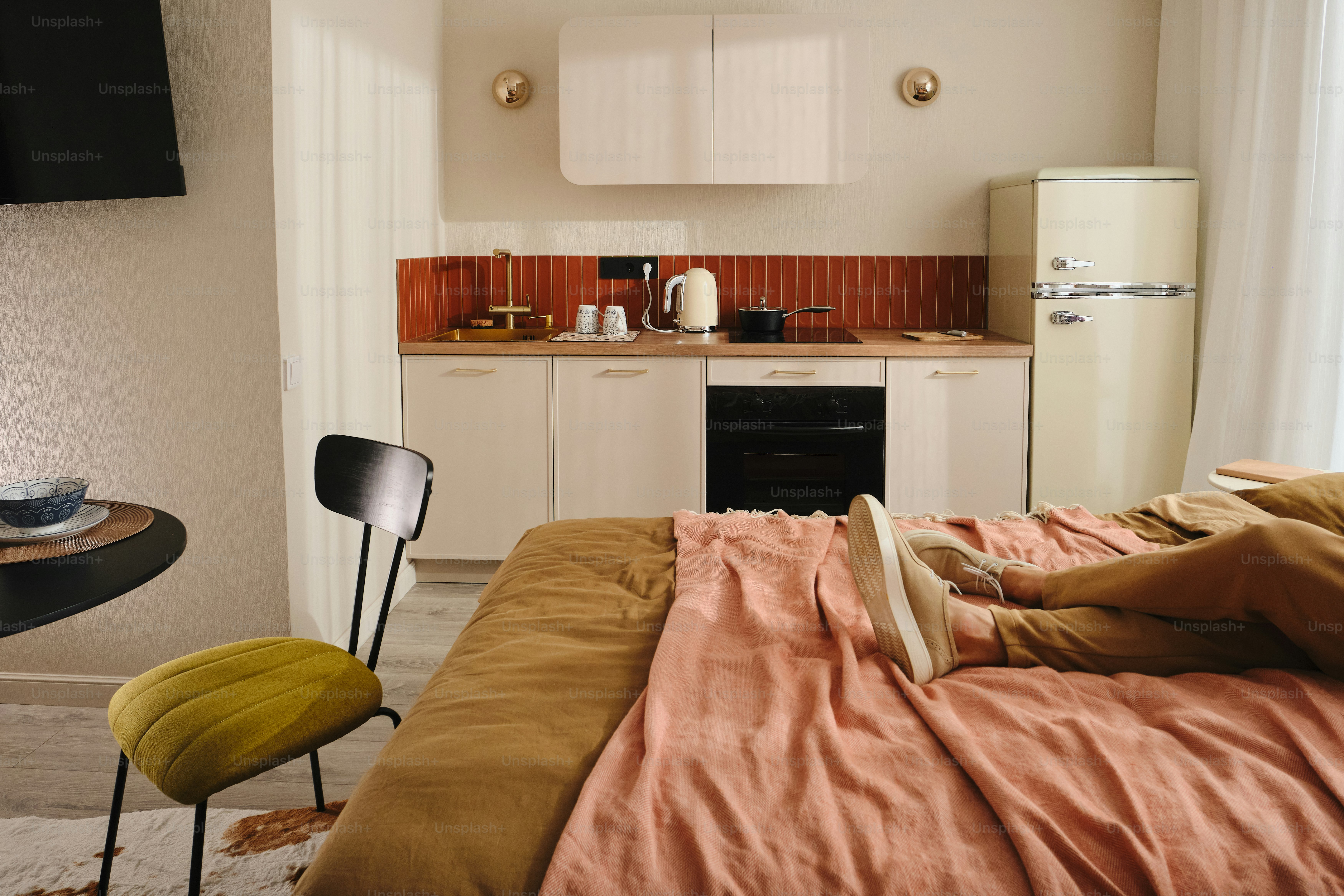Cozy studio apartment with kitchenette and bed.