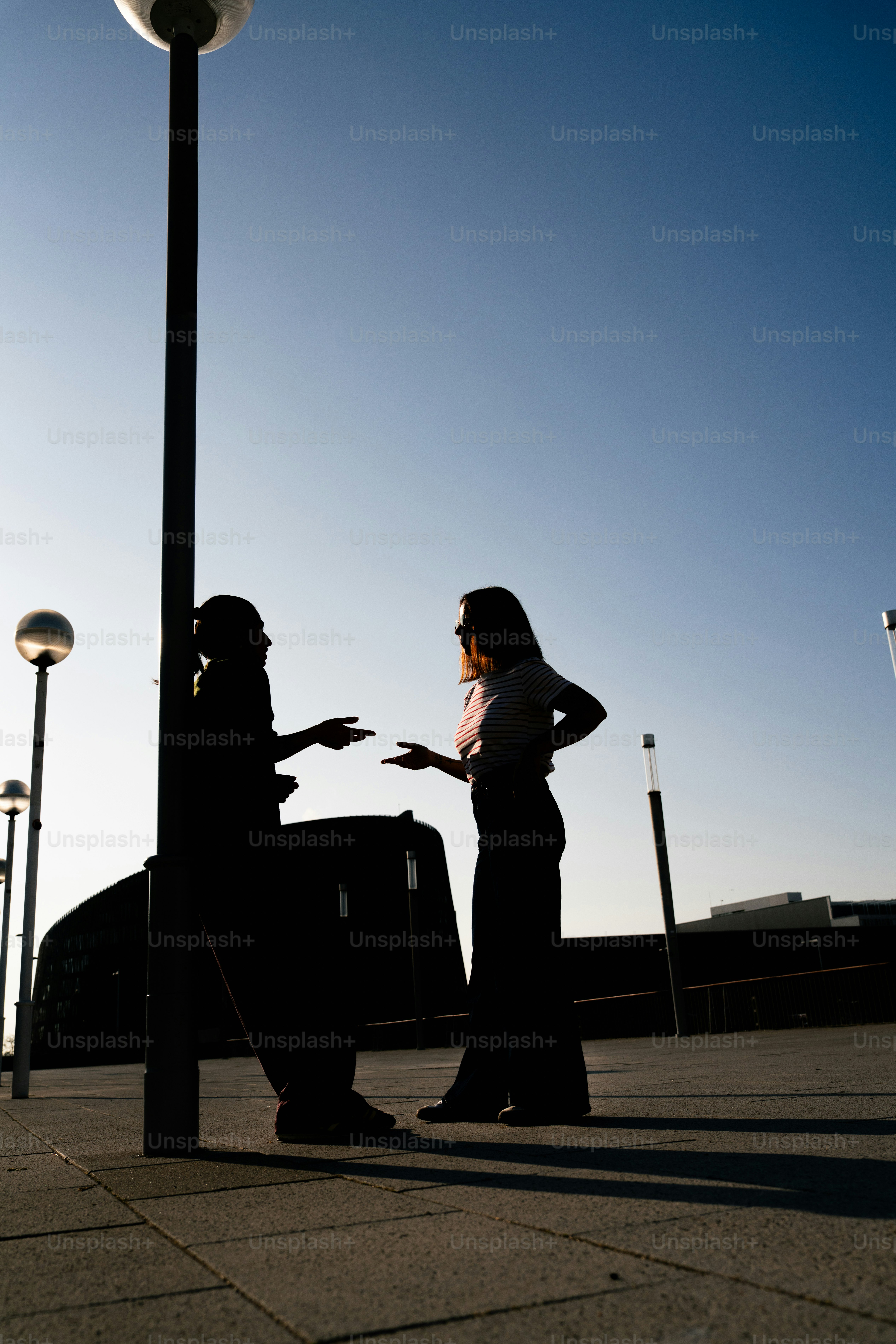 하늘을 배경으로 두 사람이 실루엣으로 대화하고 있다
