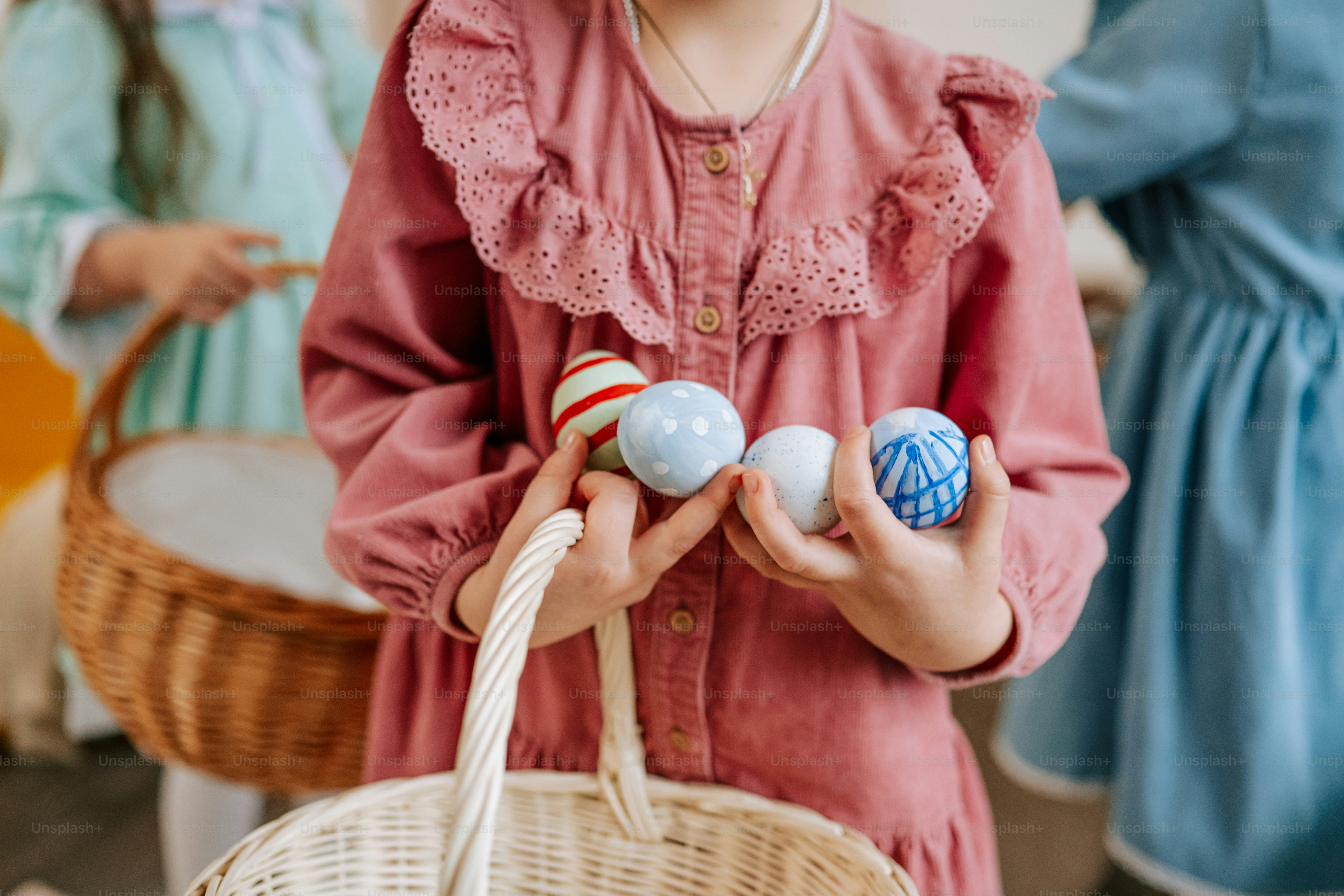 Kind hält verzierte Ostereier und einen Korb.