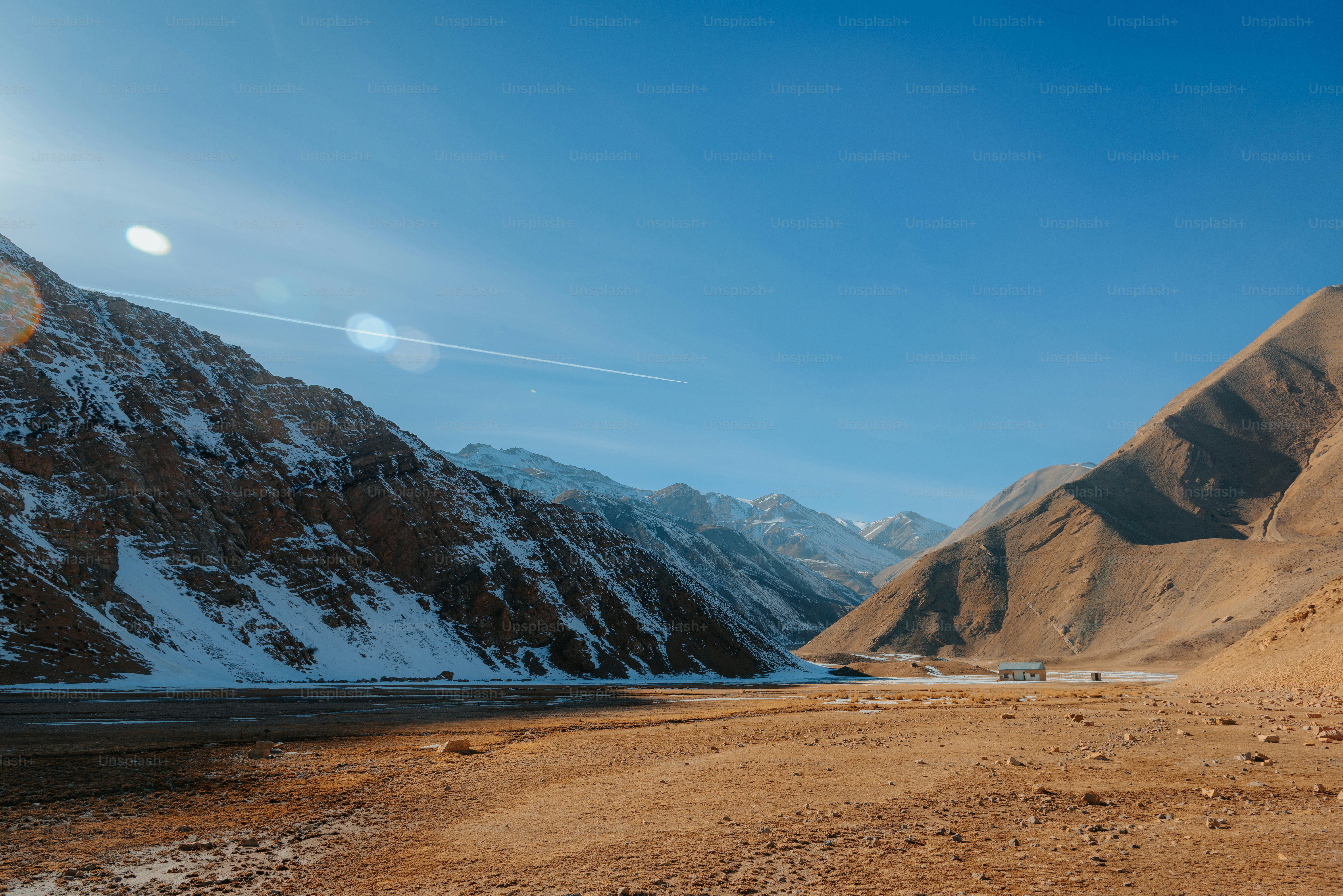 Sunlit mountain valley with snow and clear blue sky