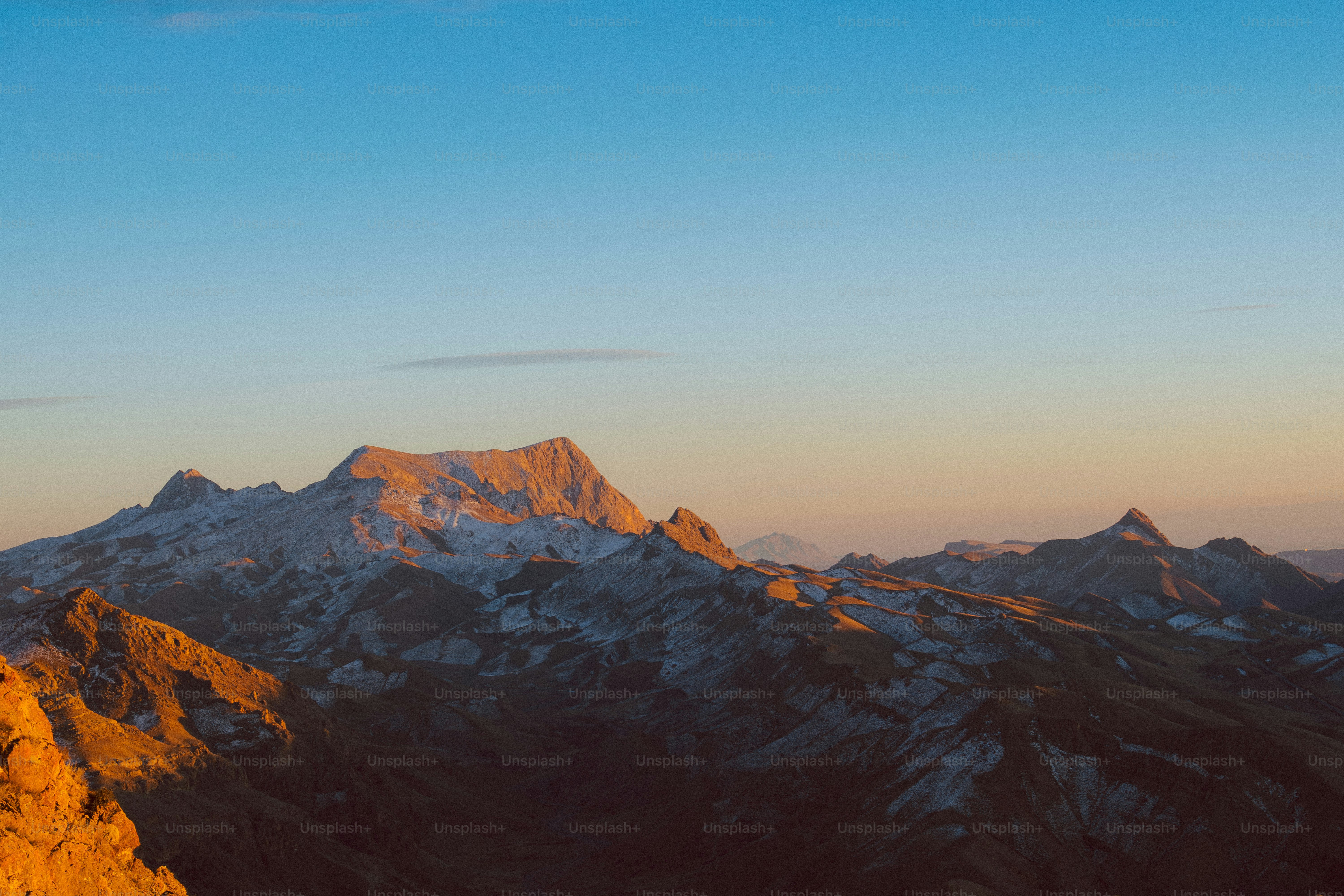 Majestic mountain range bathed in golden sunset light.