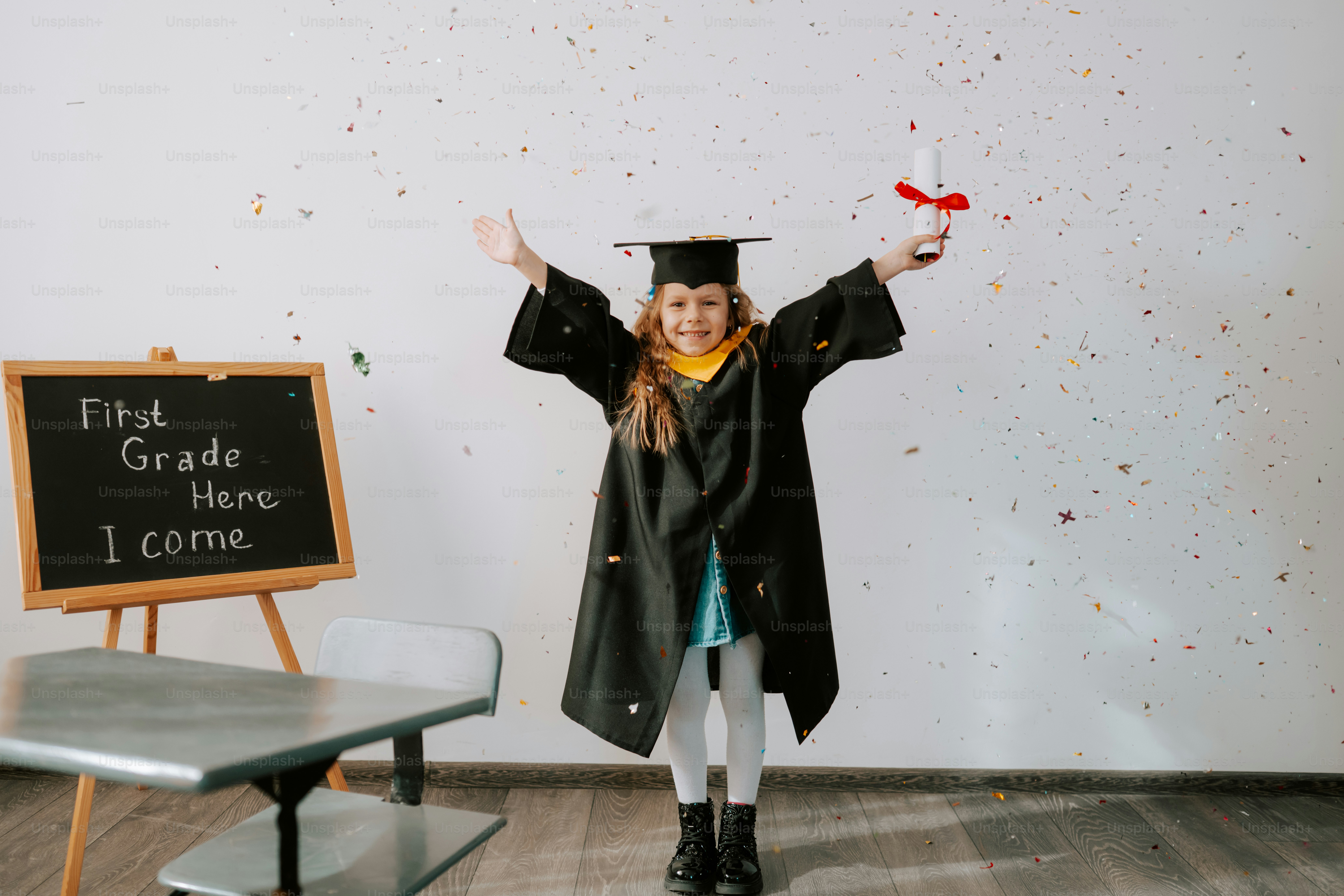 A girl in graduation attire holds a diploma and celebrates.
