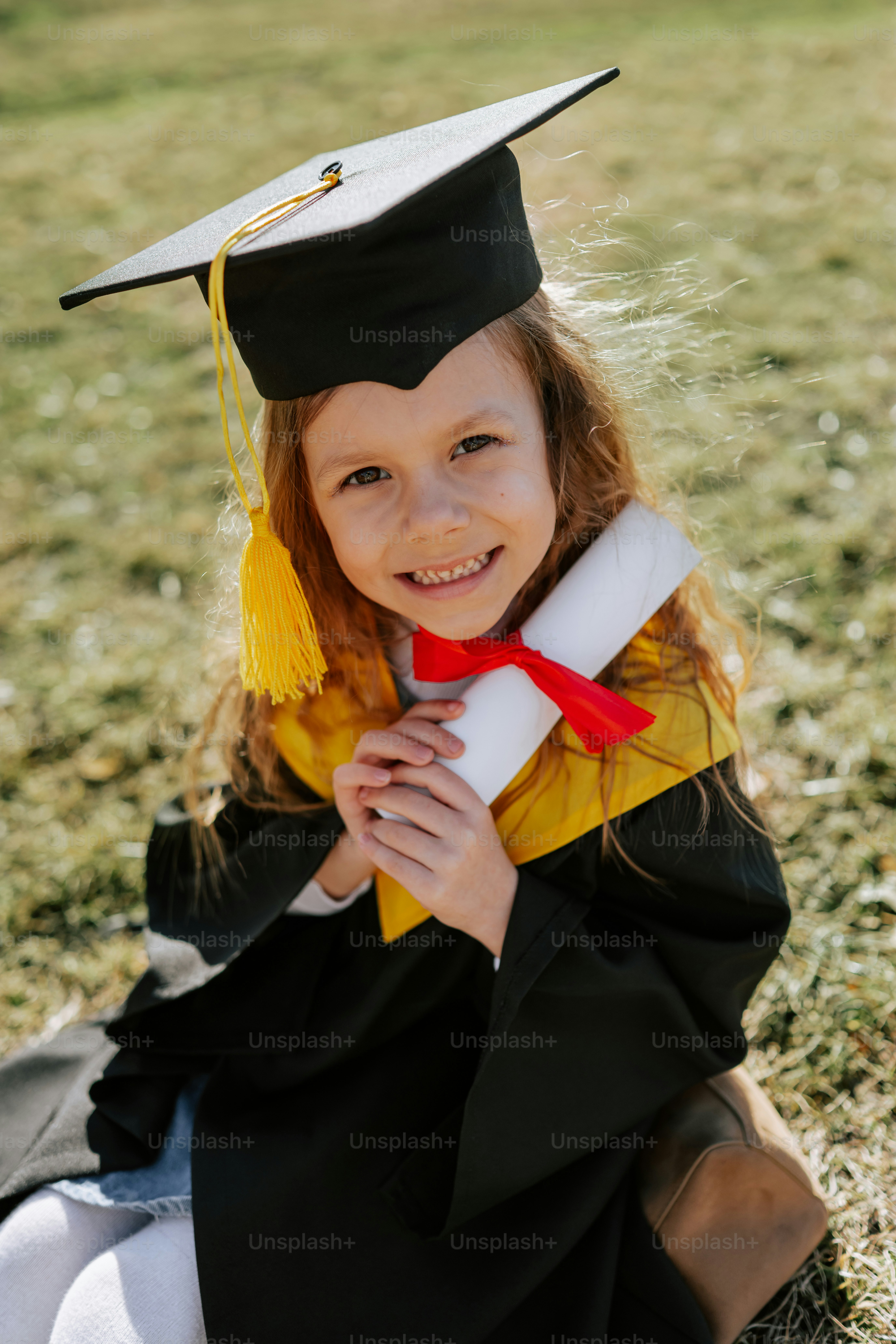 A smiling girl in graduation cap and gown holds diploma
