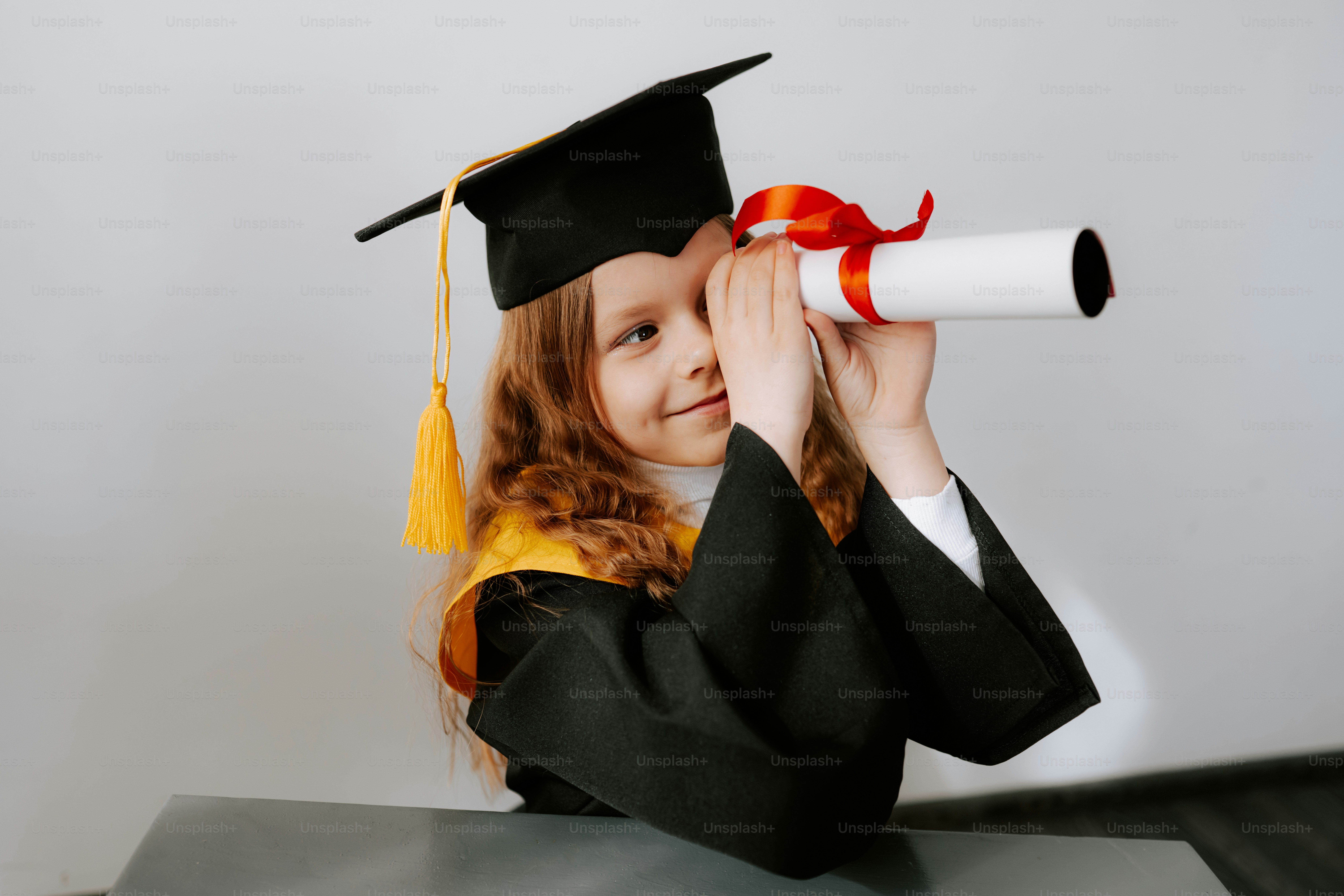 Young graduate looks through diploma like a telescope