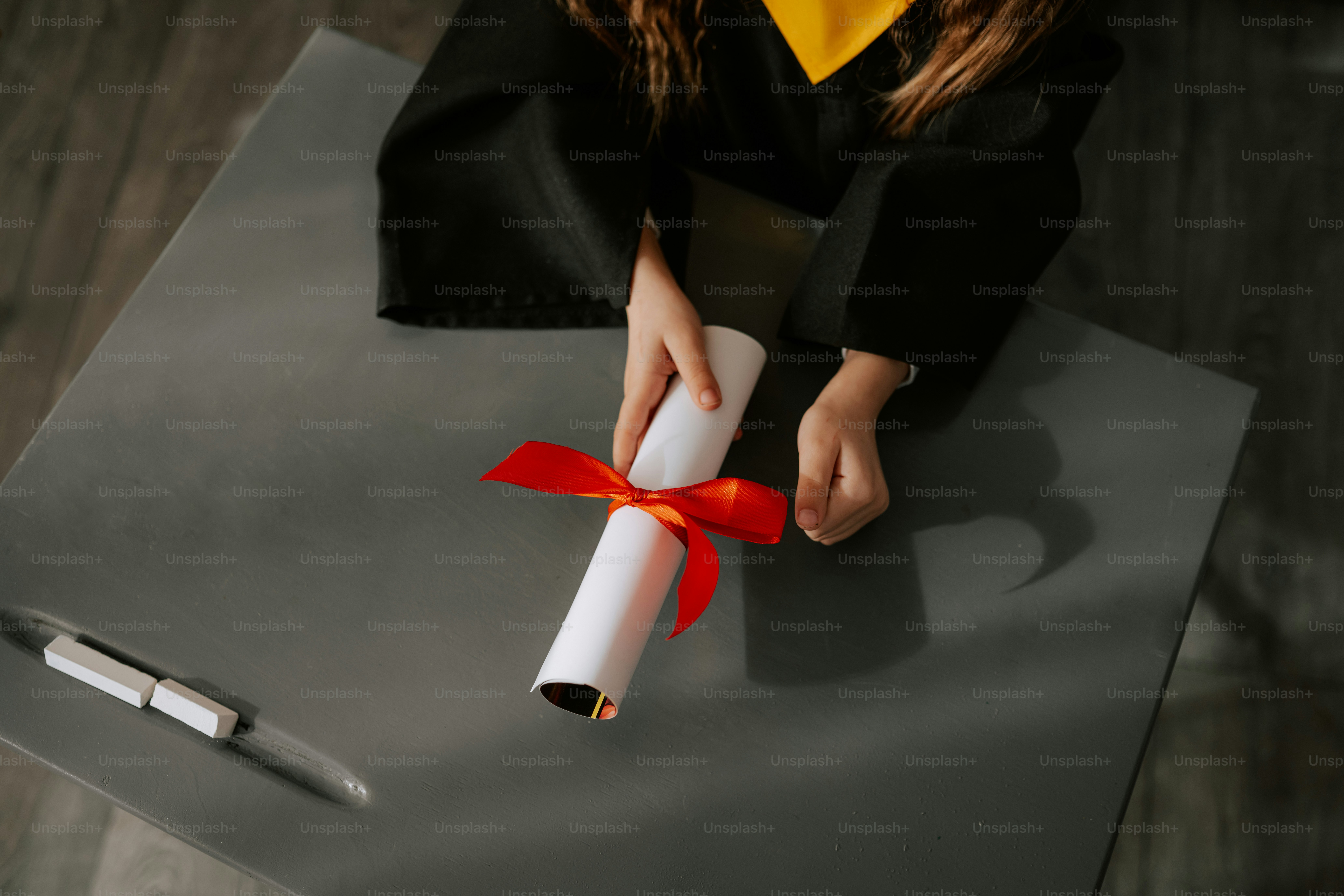 Graduating student holds diploma tied with red ribbon. photo ...