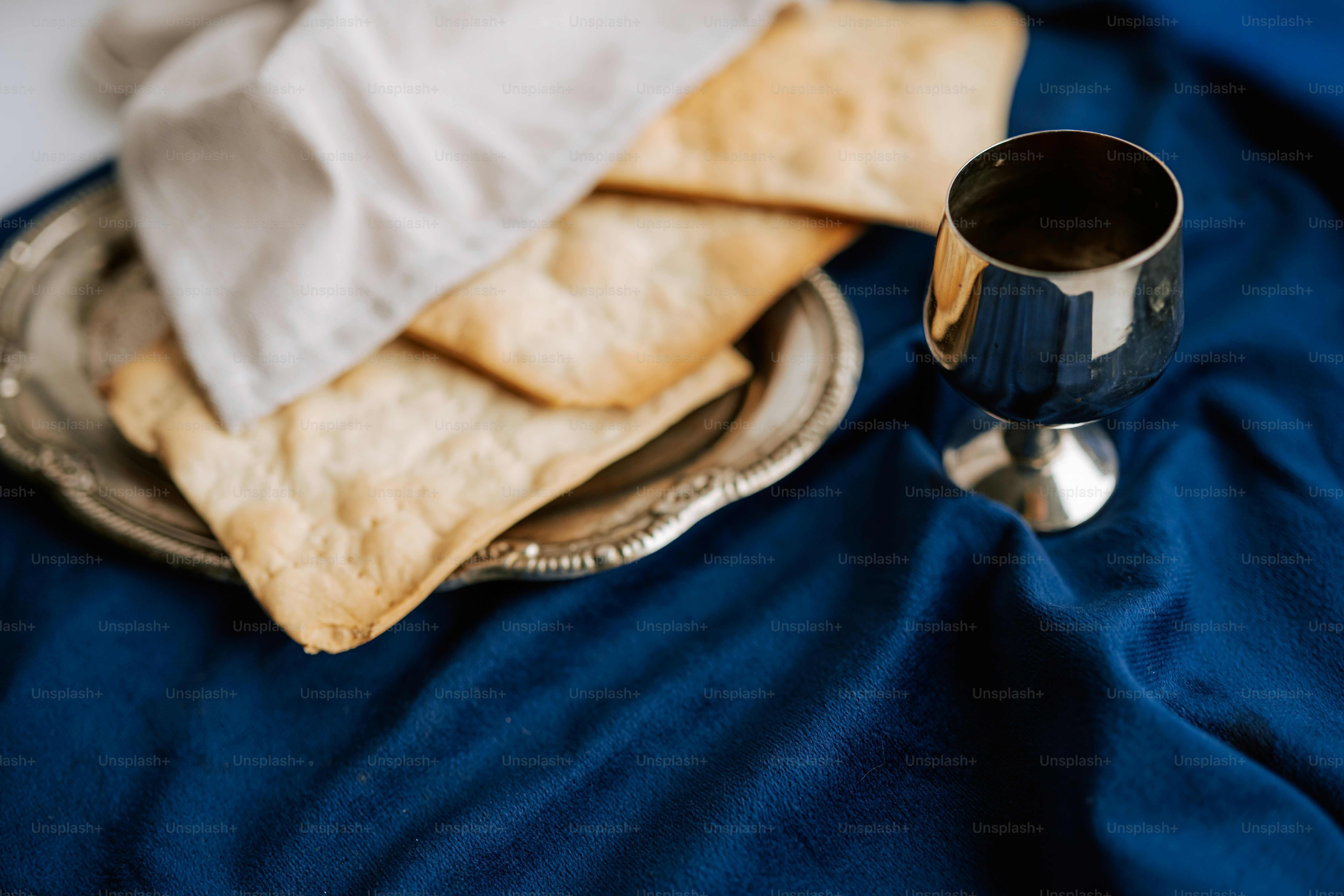 Bread and wine on a silver plate with cloth.