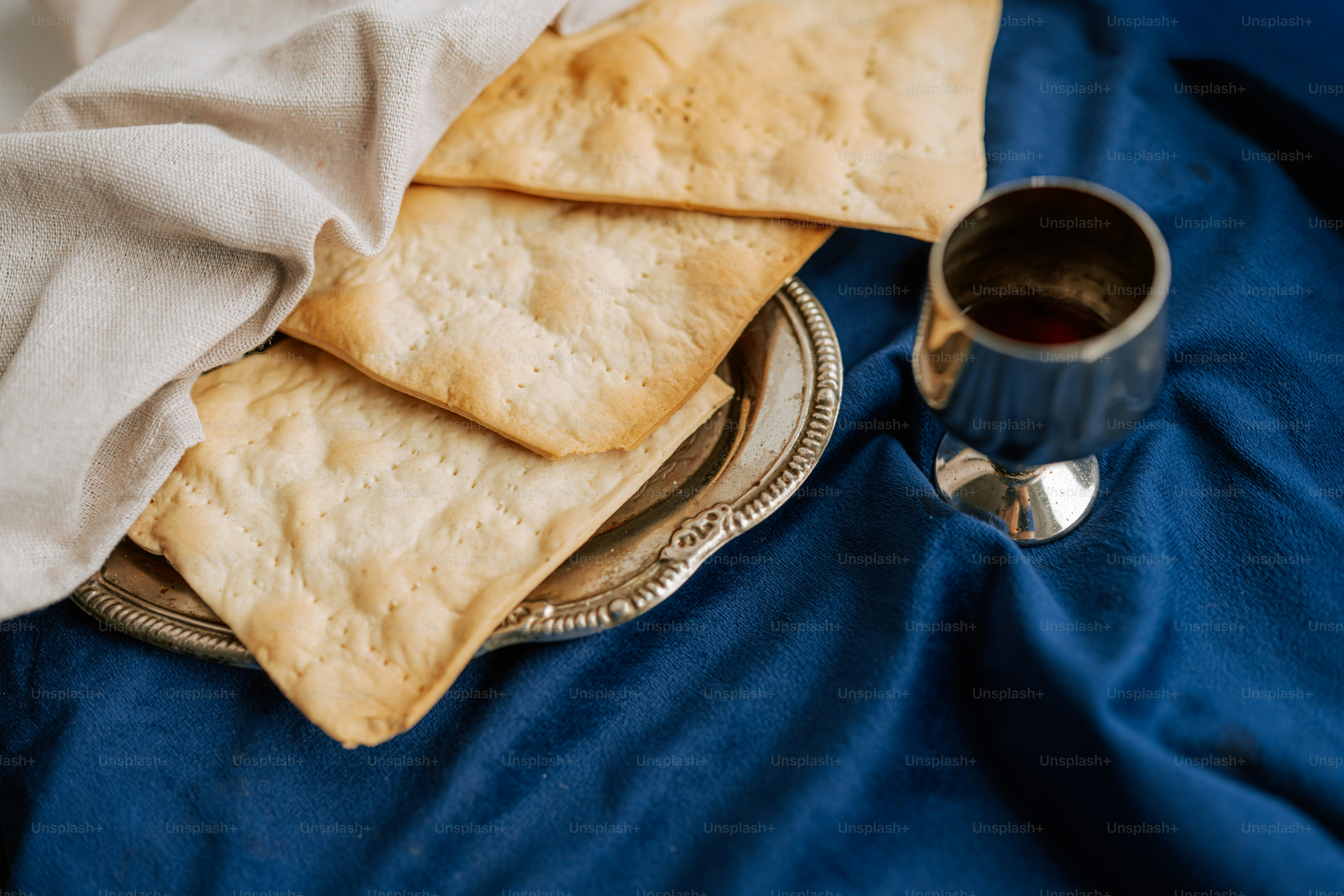 Matza-Brot auf einem silbernen Teller mit Wein.
