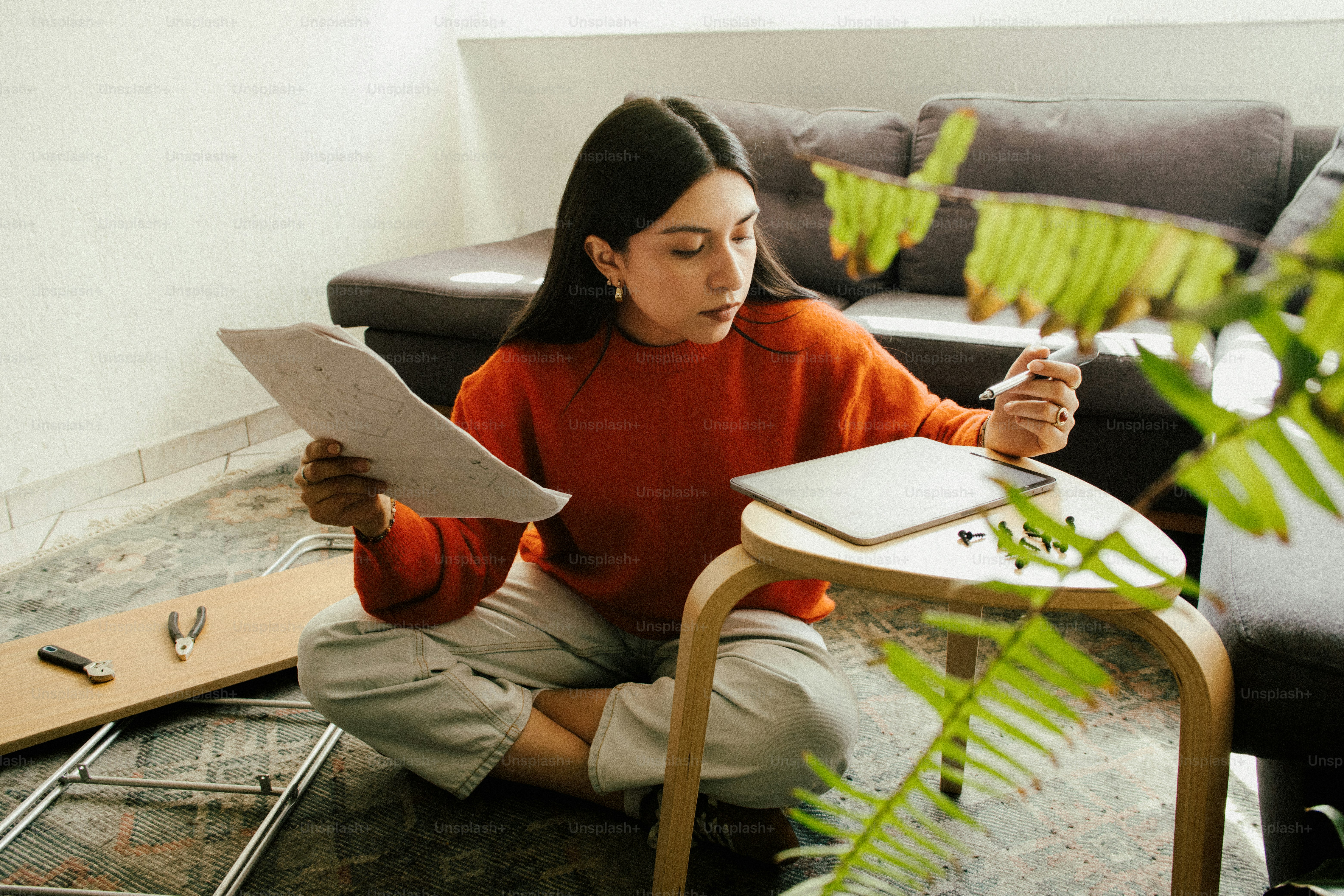 Wanita muda belajar dengan kertas dan laptop.