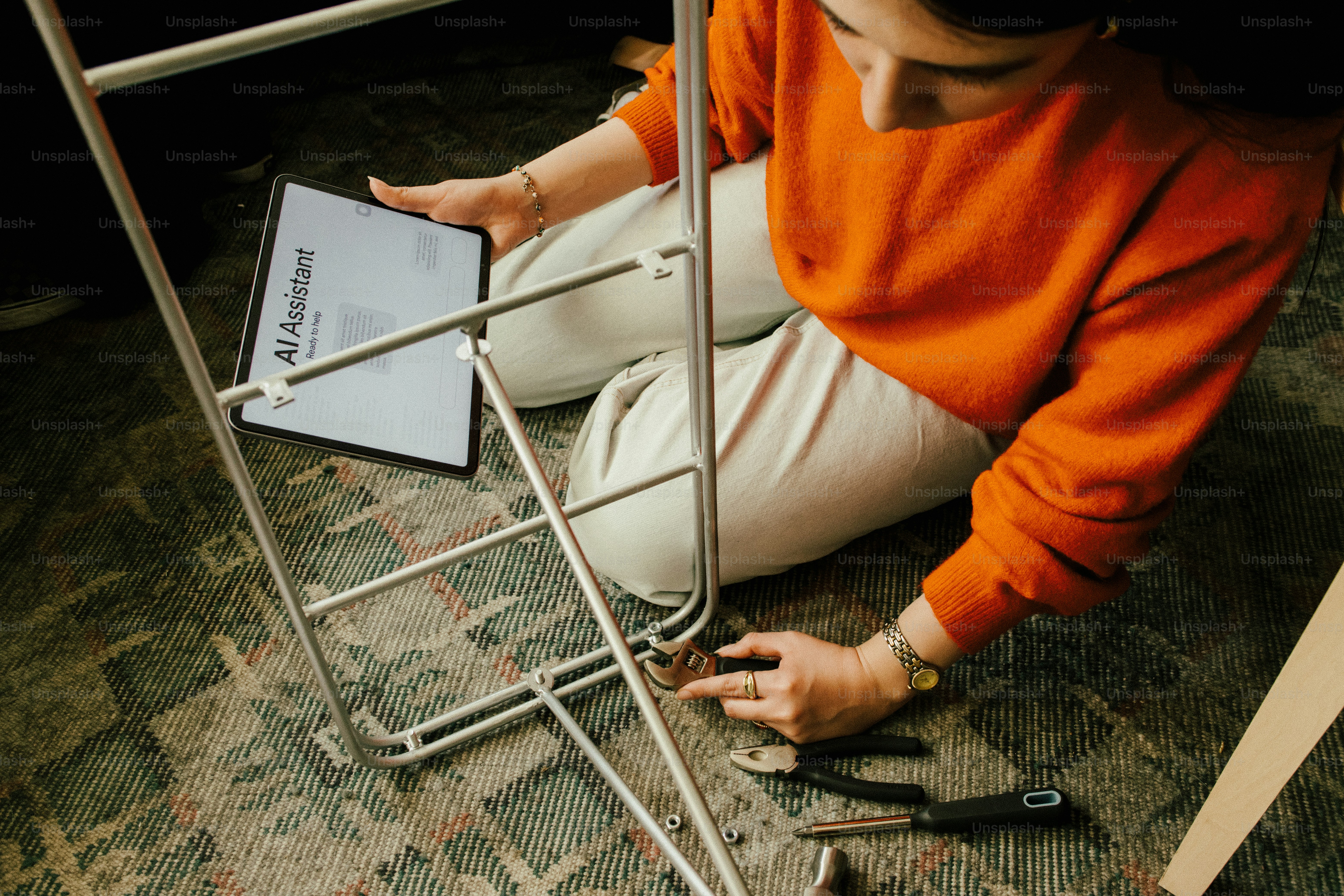 Wanita merakit furnitur menggunakan instruksi pada tablet.