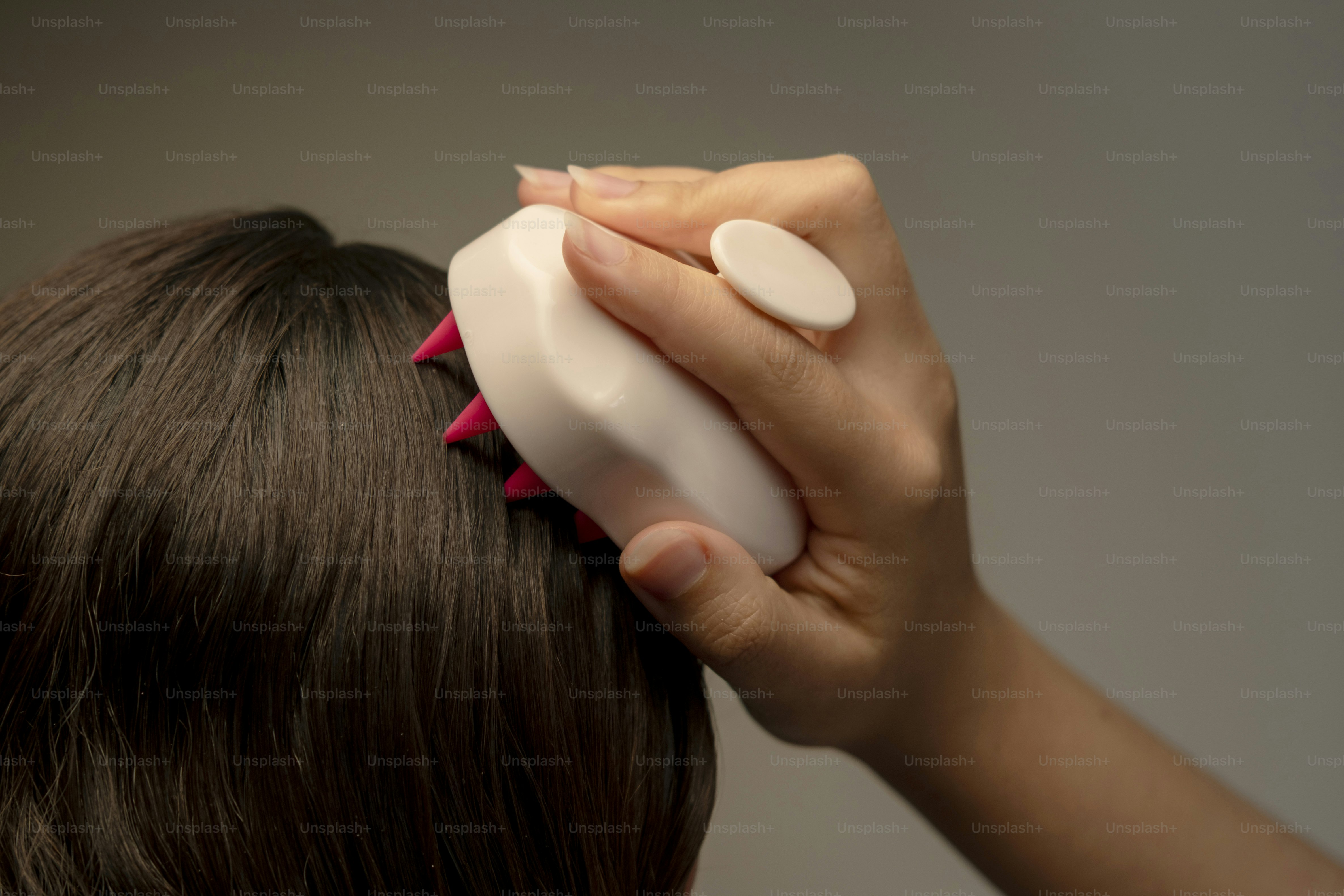 A hand combs curly brown hair with a wooden comb photo – Beauty Image ...