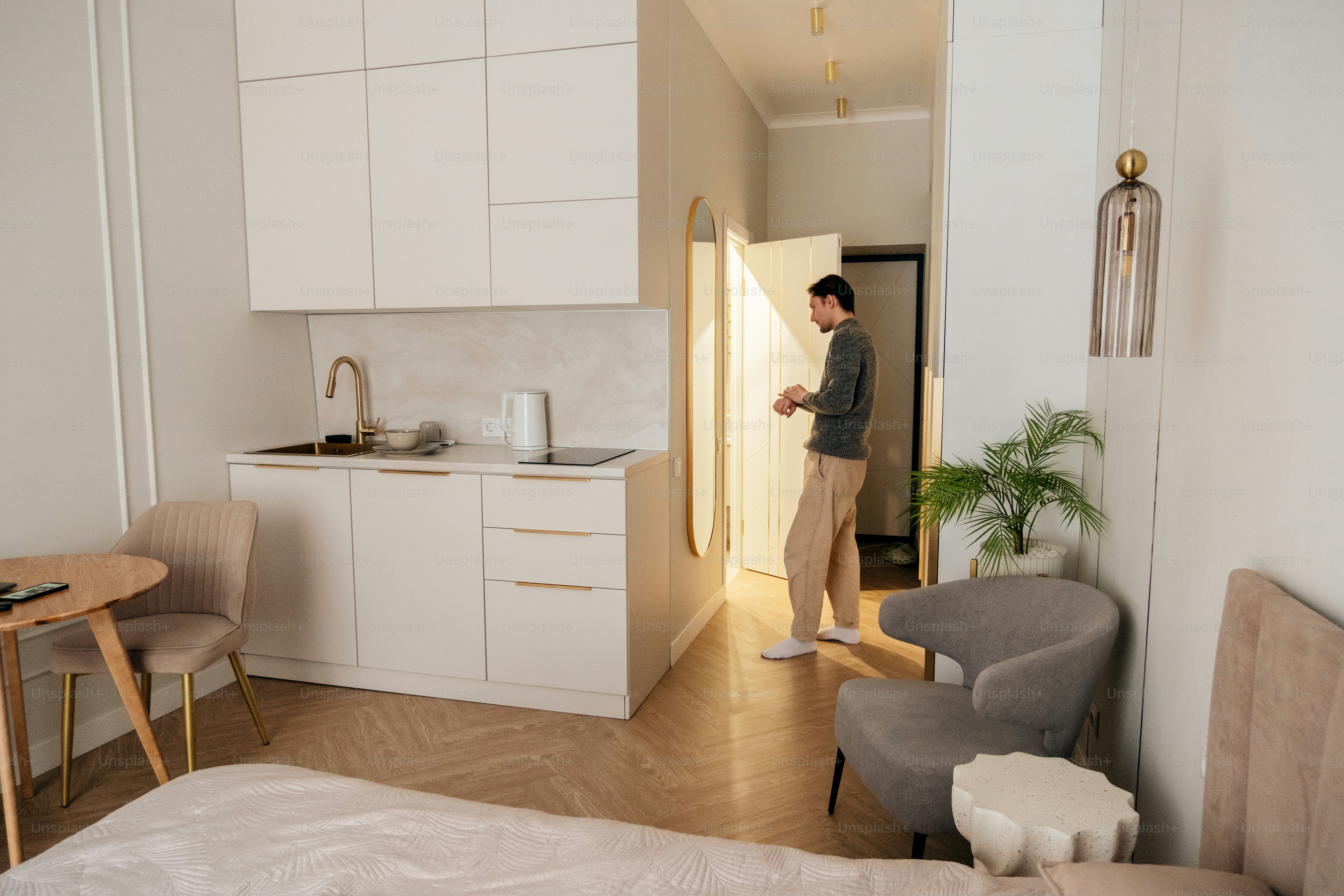 Man entering a modern studio apartment with kitchenette