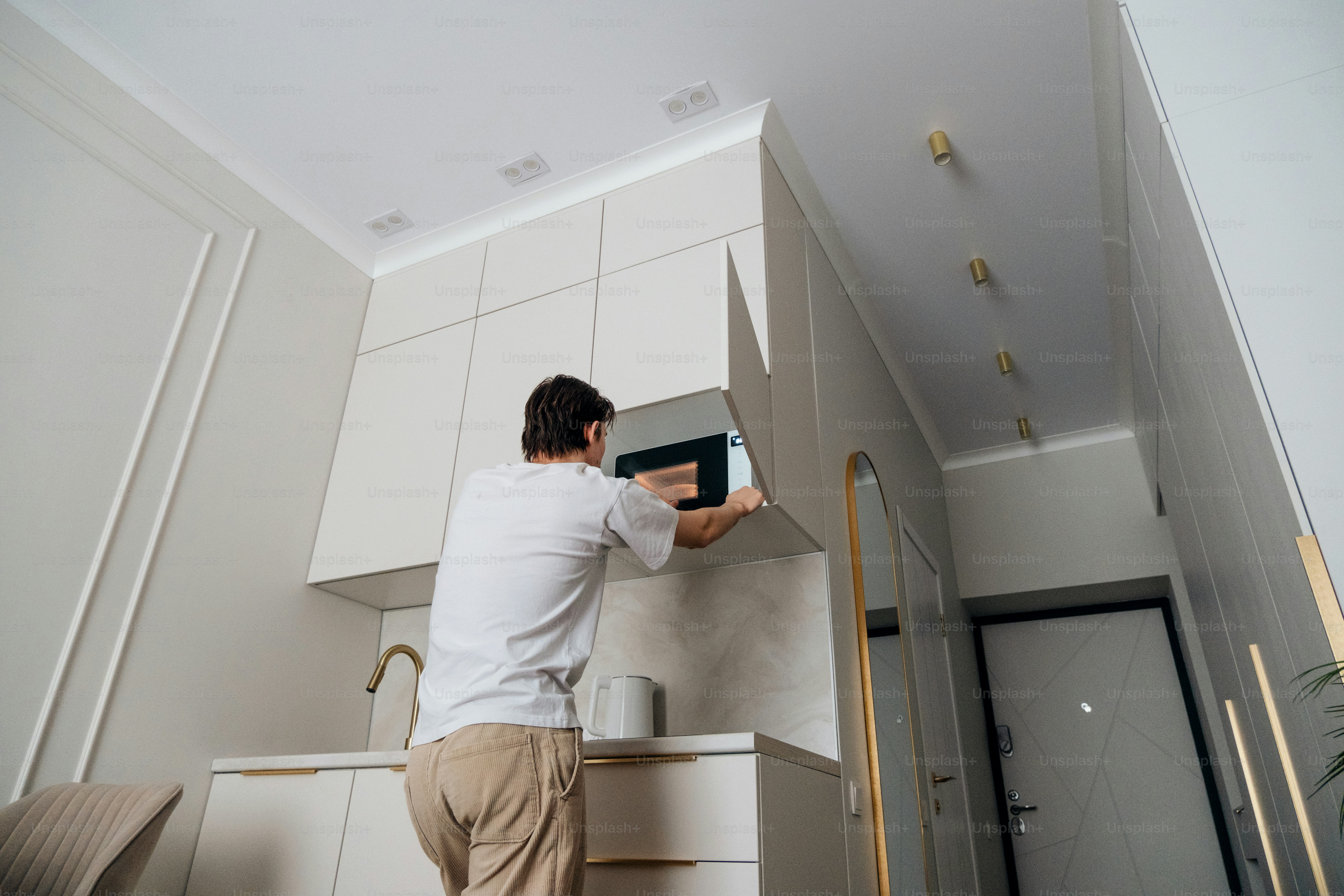 Man placing food in a built-in microwave.