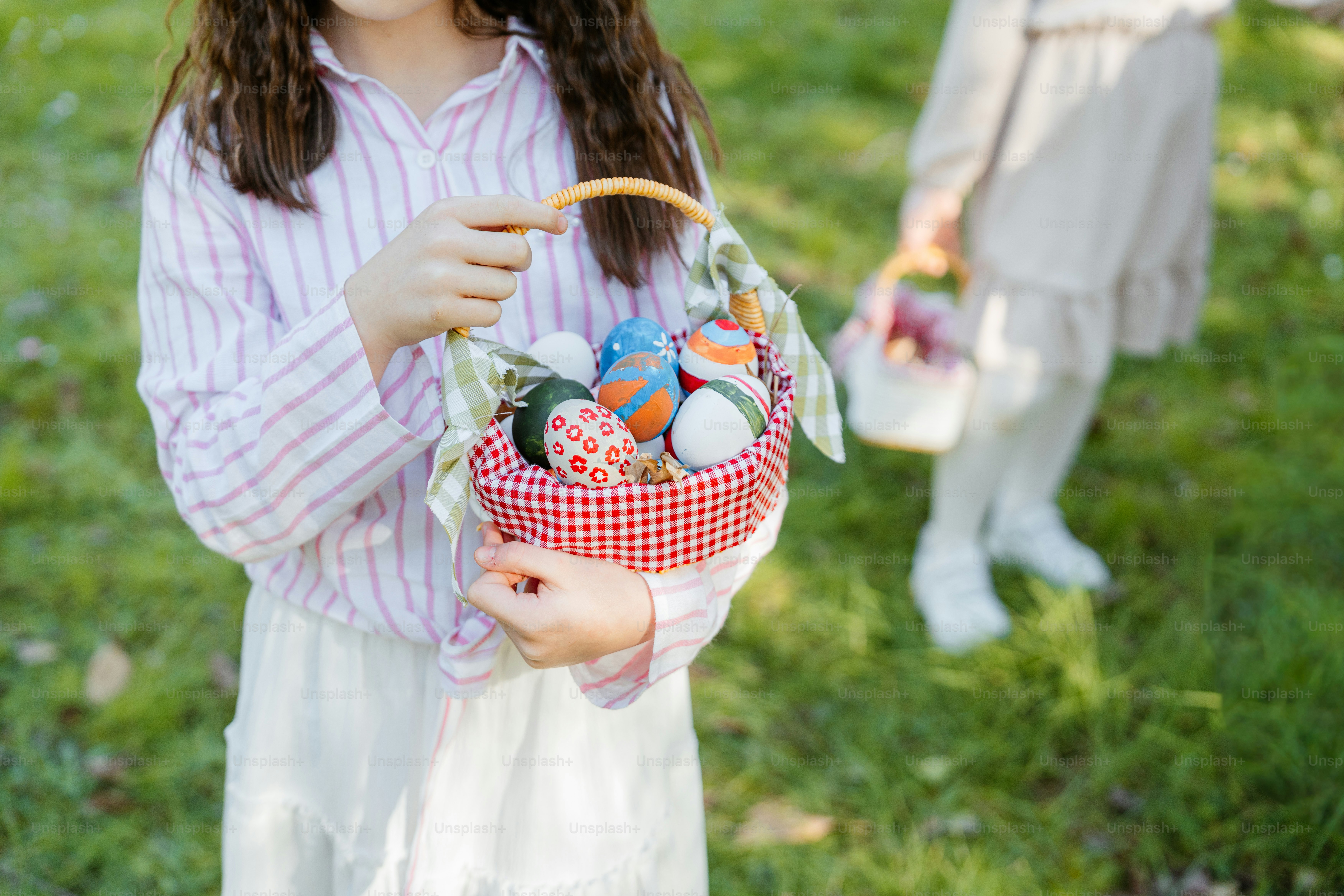 알록달록한 부활절 달걀 바구니를 들고 있는 아이