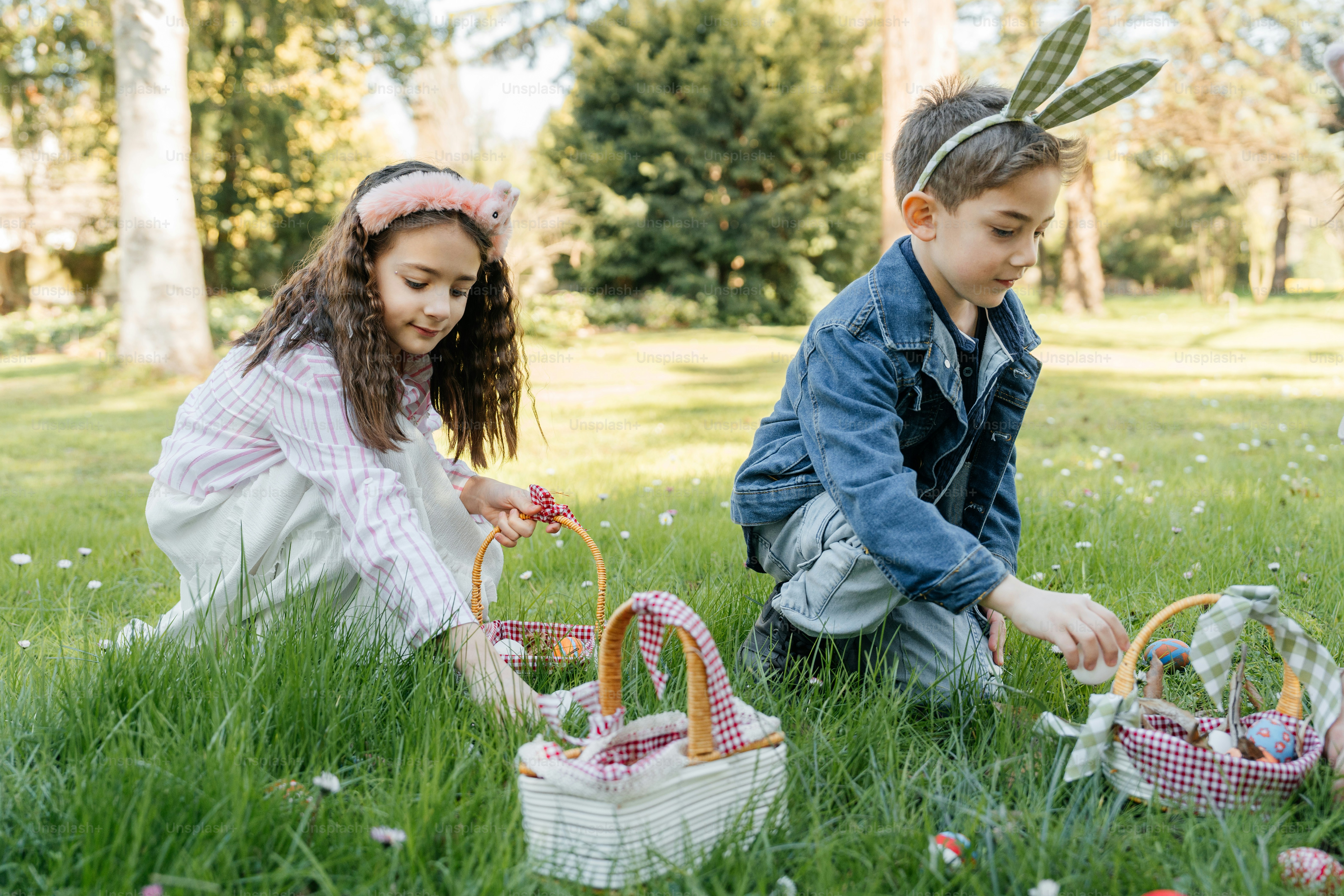 아이들이 바구니를 들고 야외에서 부활절 달걀을 찾고 있습니다