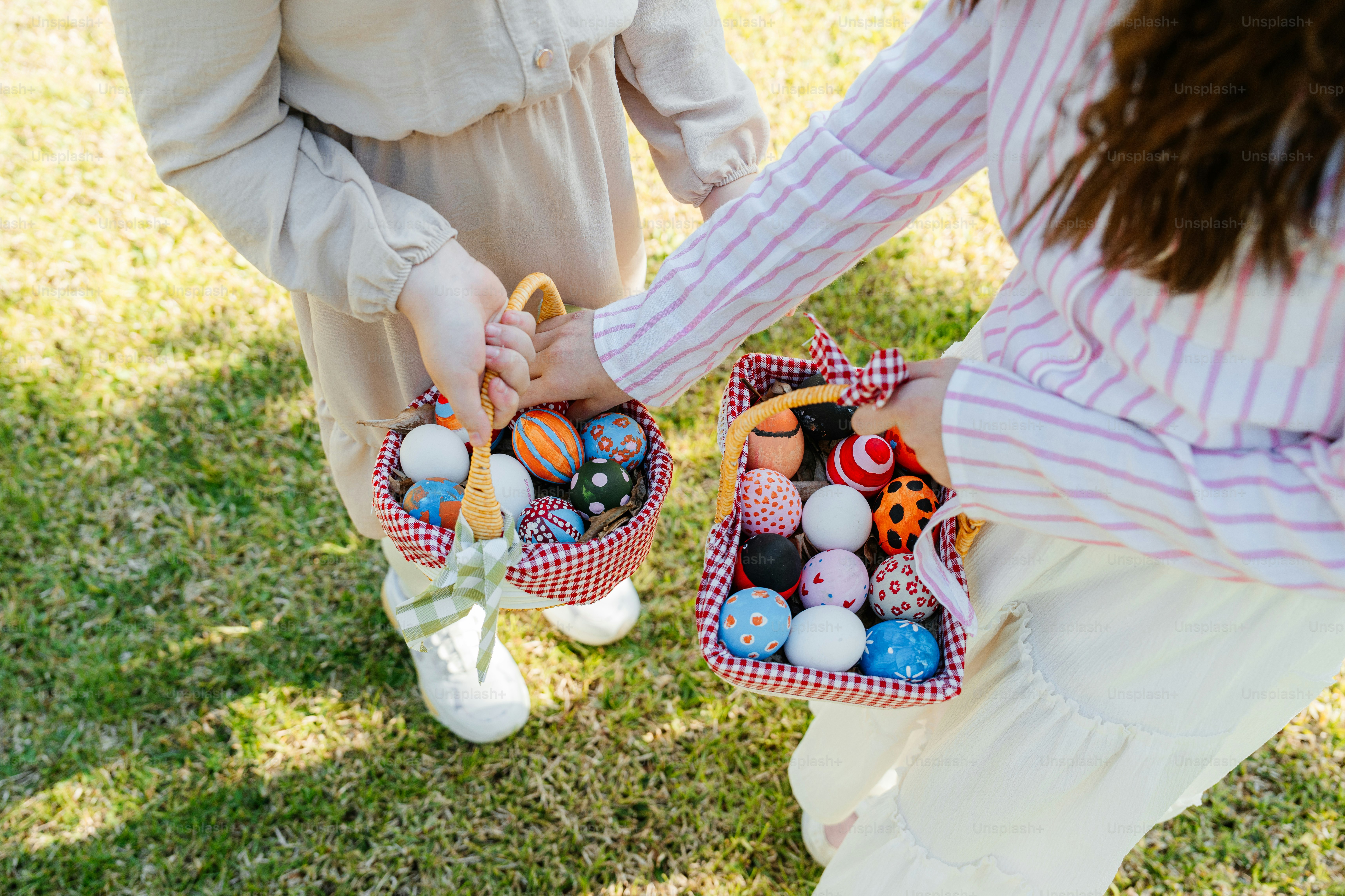 두 아이가 알록달록한 부활절 달걀이 담긴 바구니를 들고 있습니다.