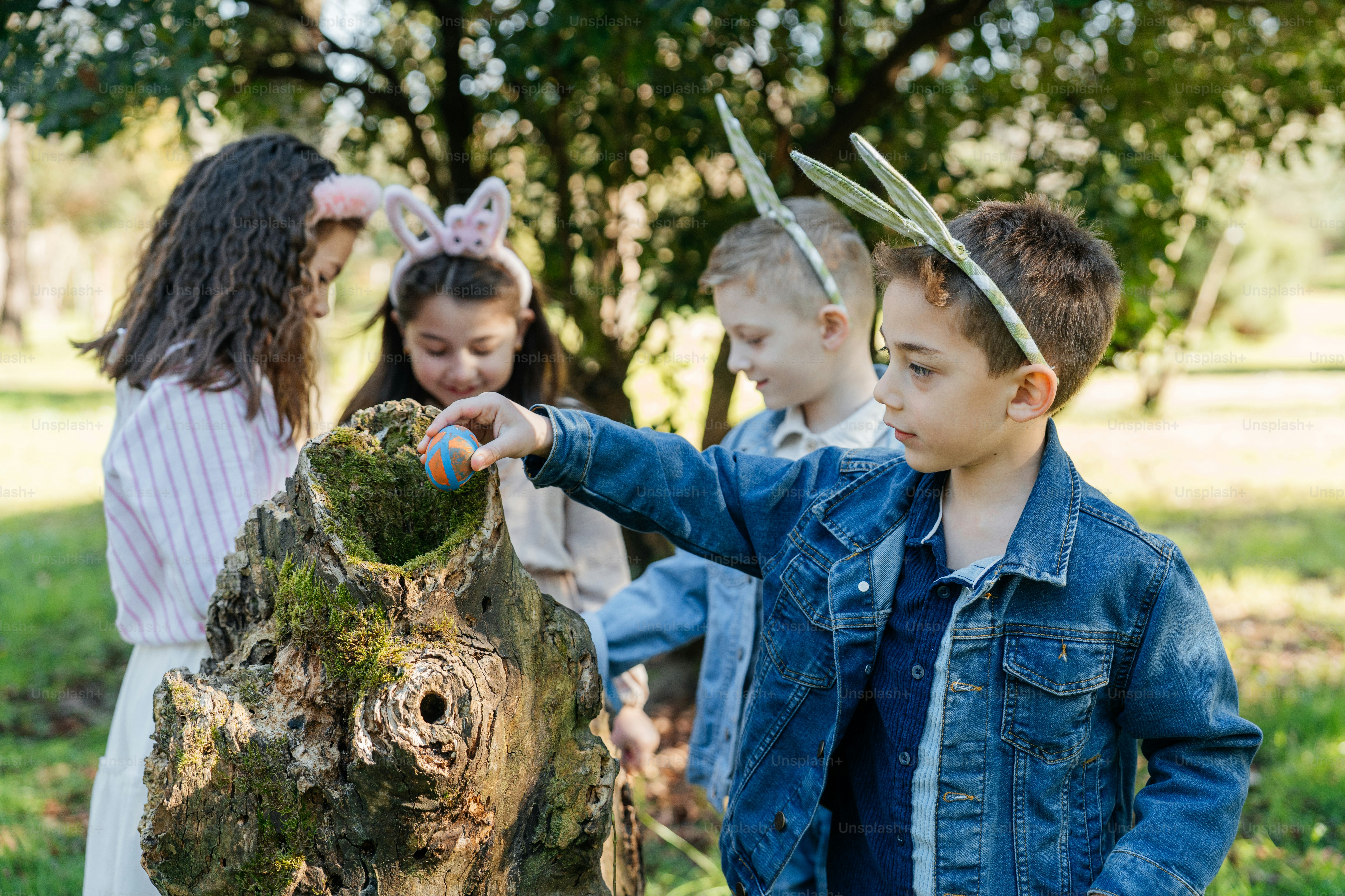 토끼 귀를 가진 아이들이 부활절 달걀을 찾는 모습