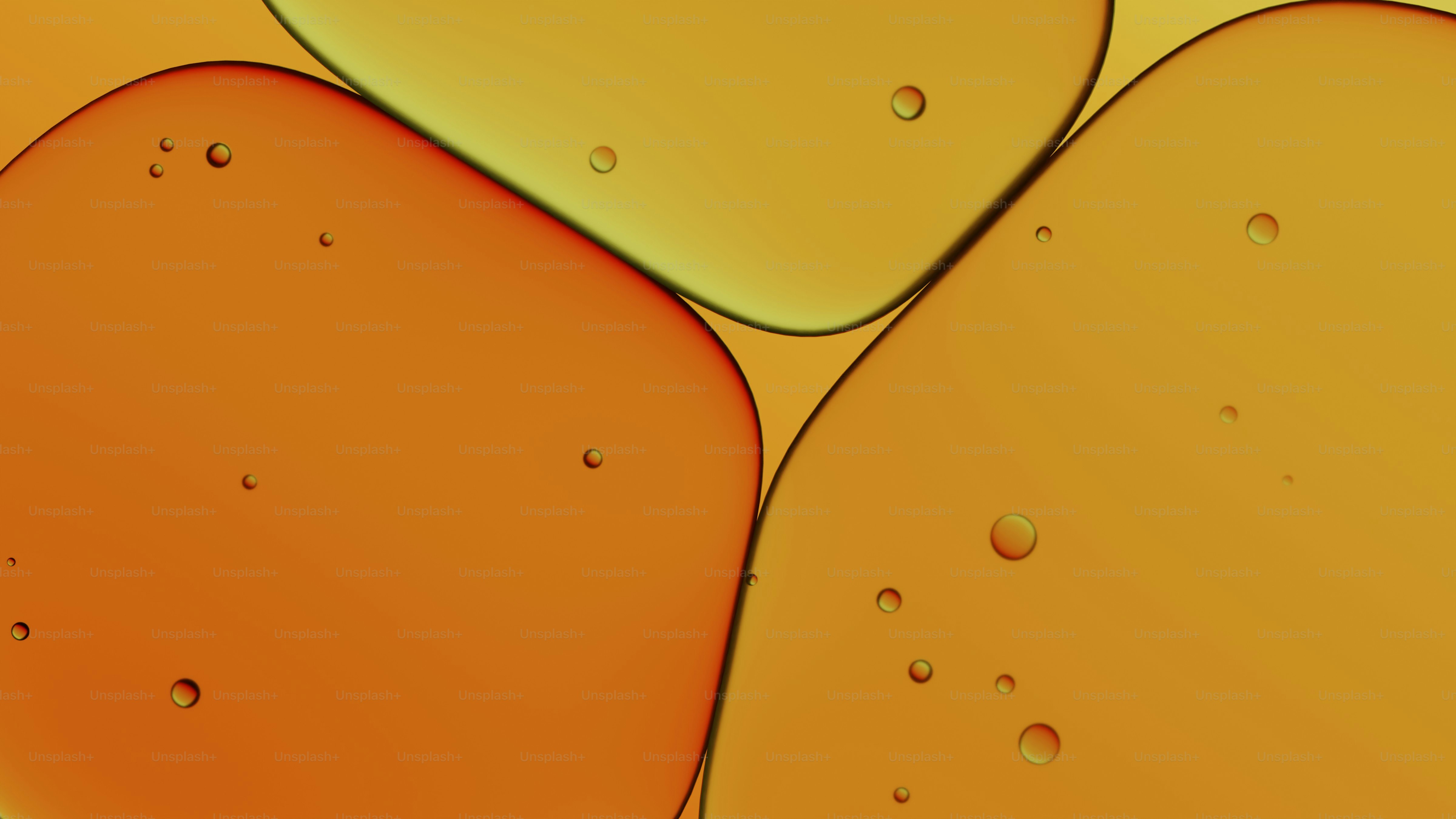 Nahaufnahme von orangen und gelben flüssigen Klumpen mit kleinen Blasen.